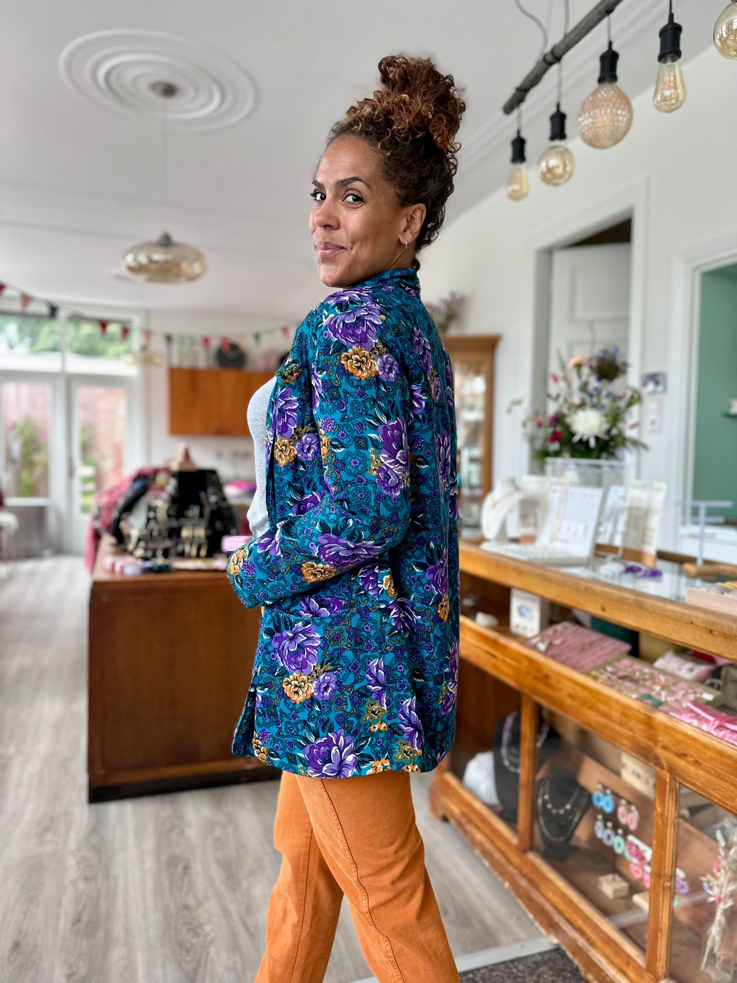 Zij-aanzicht van de vintage zomerjas in petrol blauw met paarse bloemen print