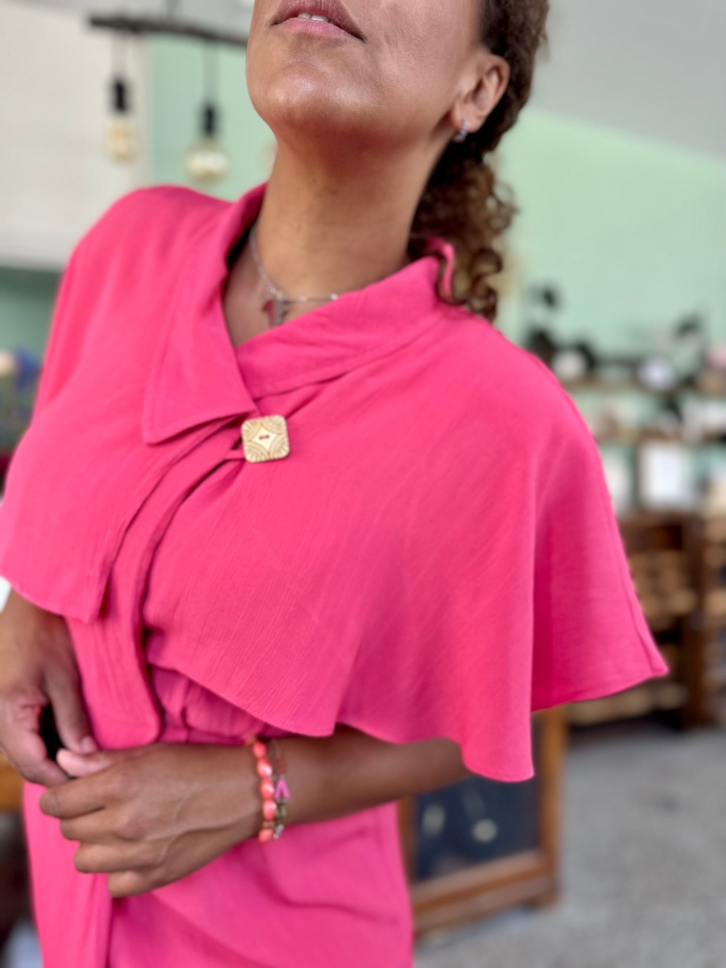 Detail van de vintage zomerjurk in fuchsia kleur met cape en sluiting rondom de borst