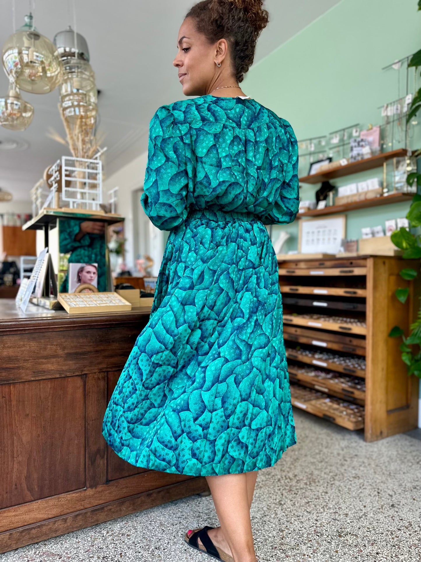 Achterkant van de vintage plooirok met bijpassende blouse in glanzende stof met subtiele print