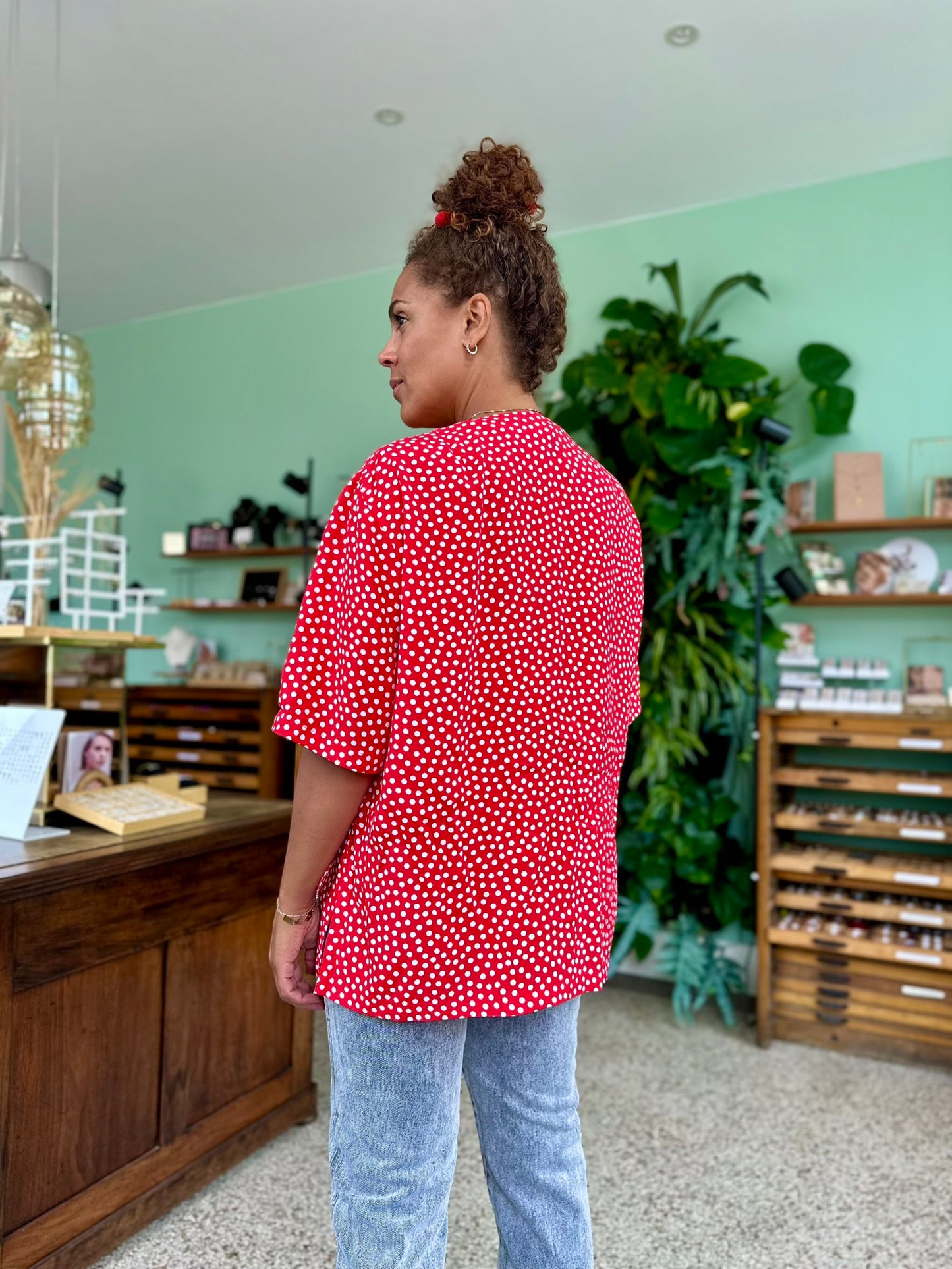 Achterkant van vintage rode blouse met witte stippen In grote damesmode
