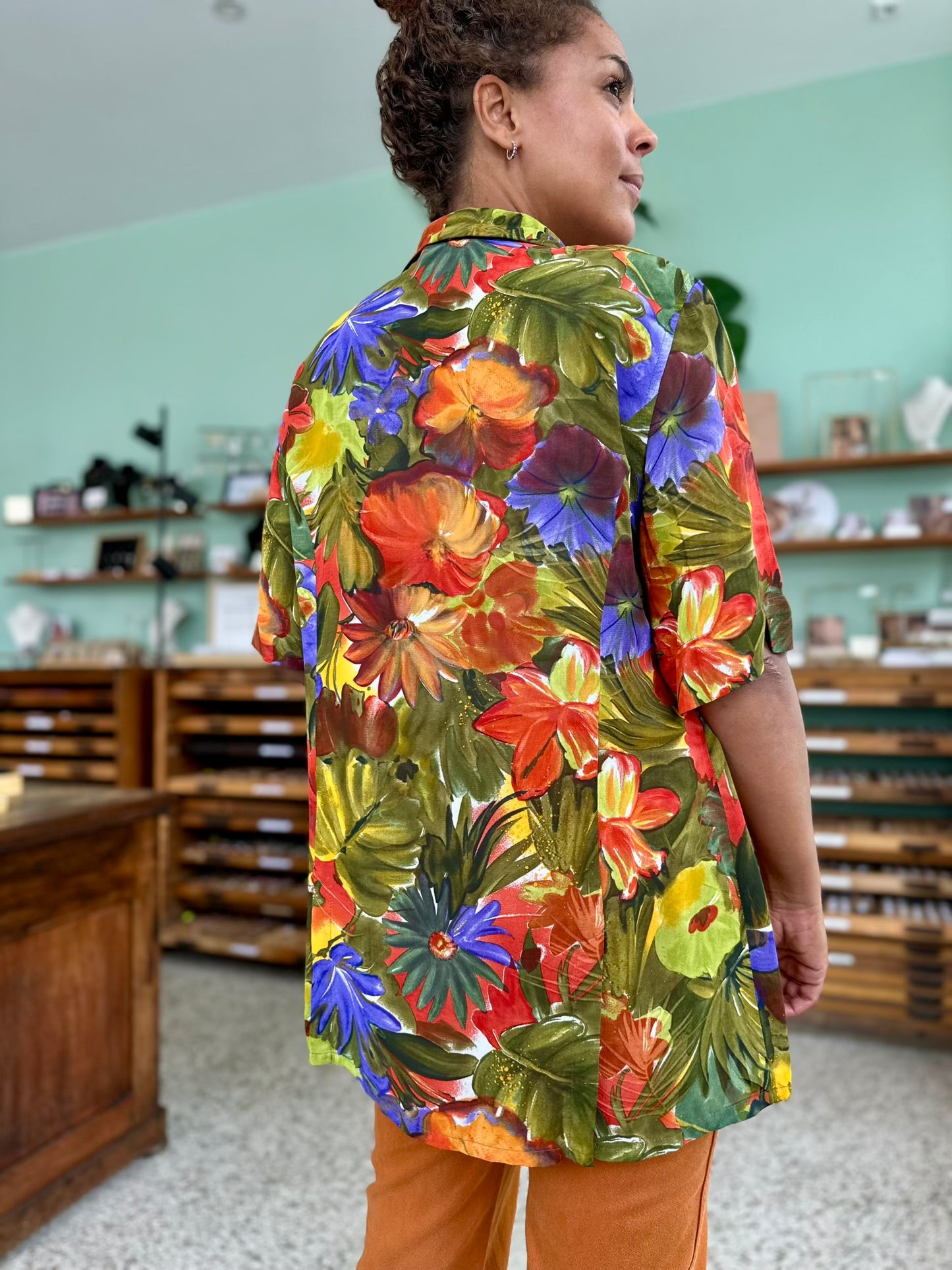 Close up van de vintage olijfgroene blouse met felle bloemen print