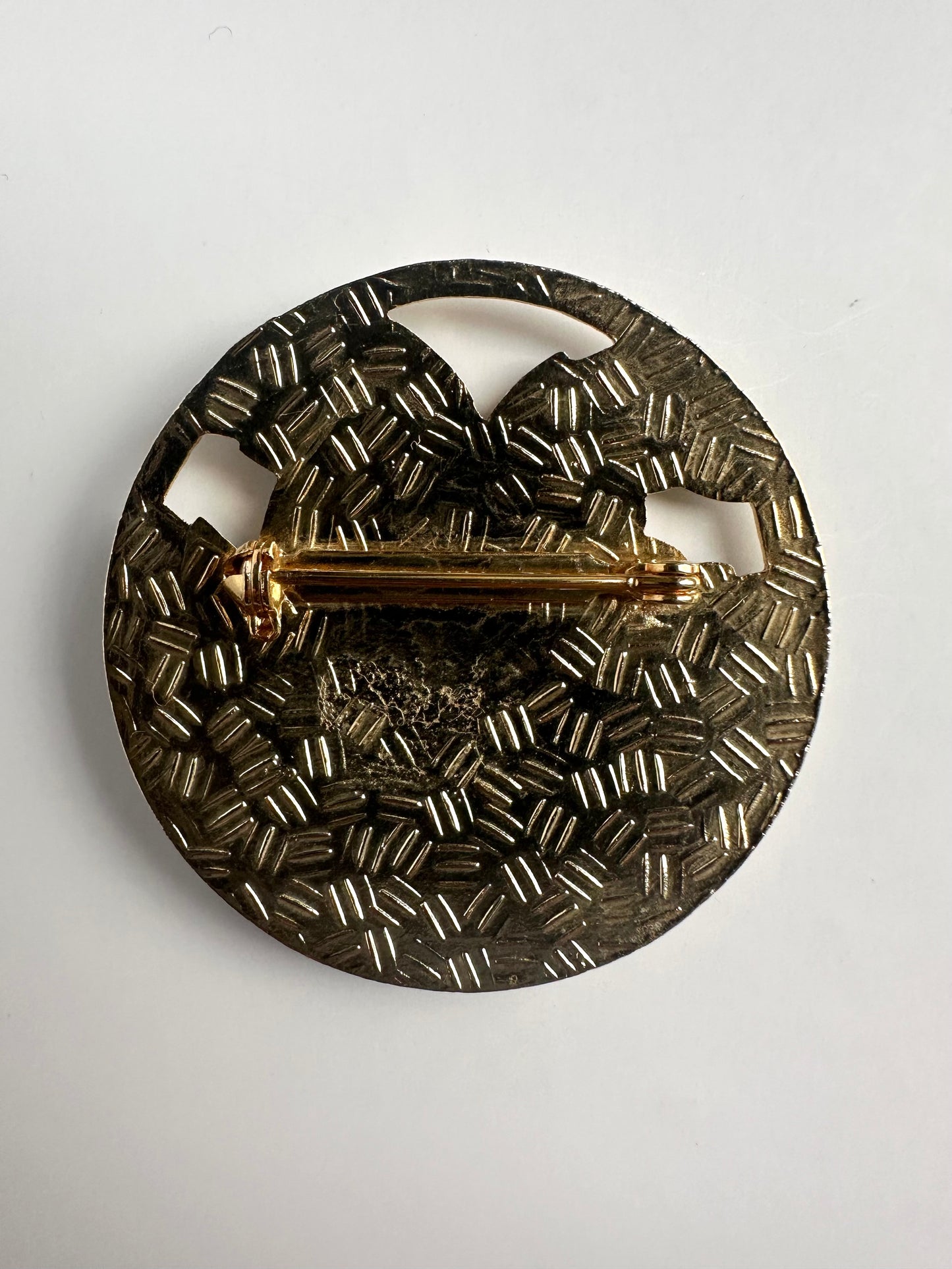 Achterkant van een ronde vergulde vintage broche