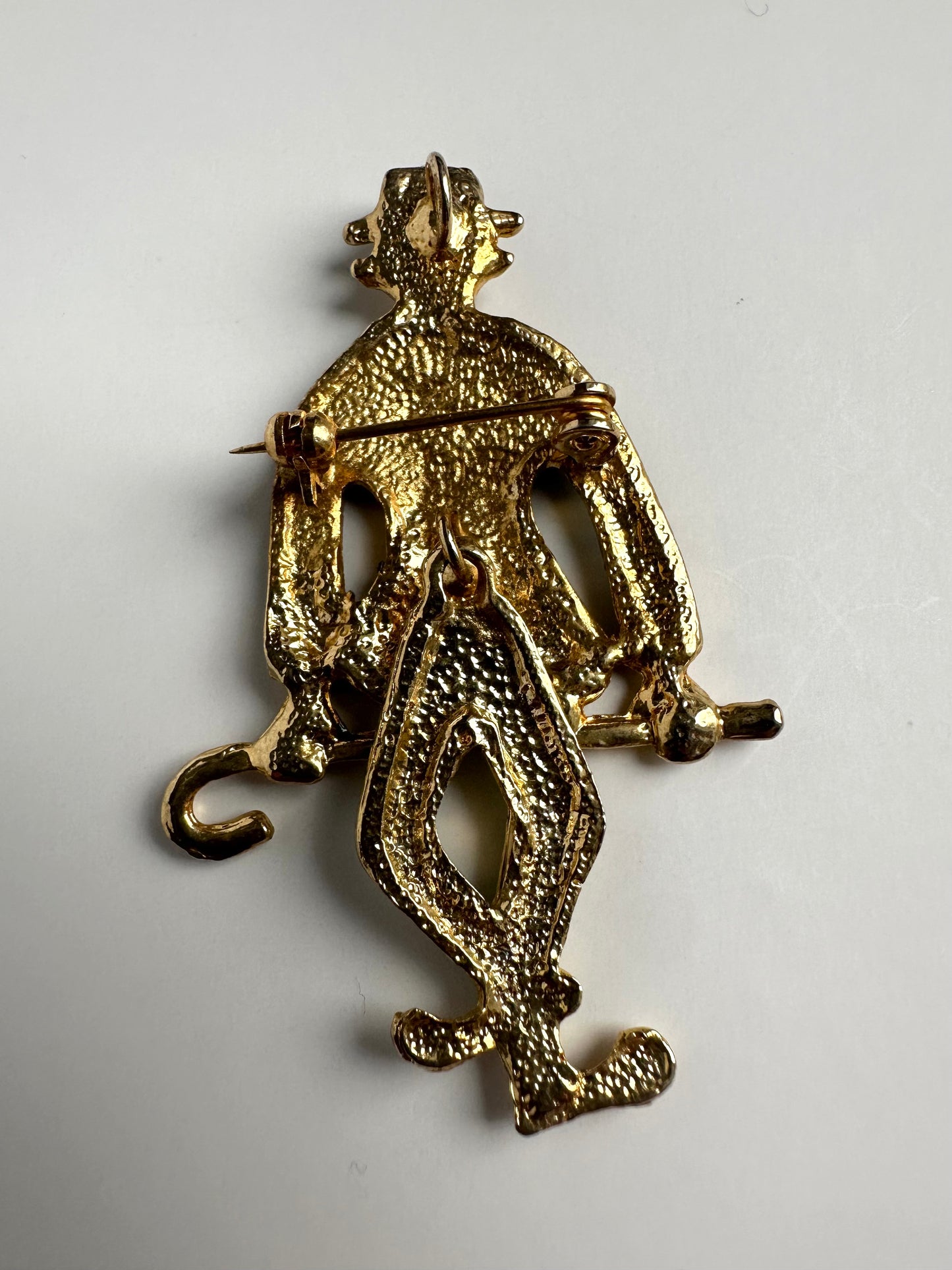 Achterkant van goudkleurige retro broche in vorm van clown