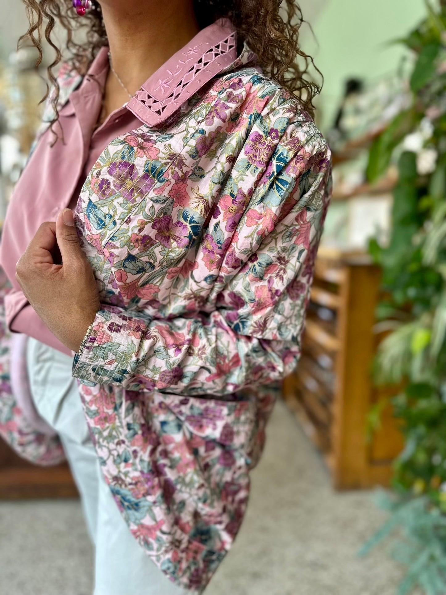 Details van elegant vintage stijl jas met bloemenprint en subtiele glans met geplooide schouders