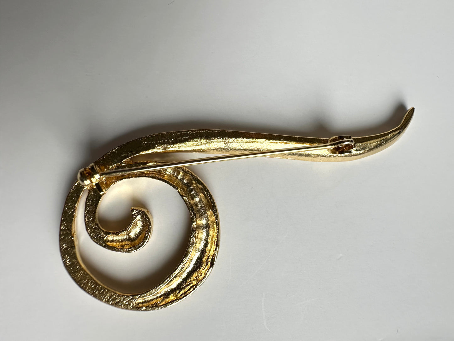 Achterkant van vintage broche in krul vorm