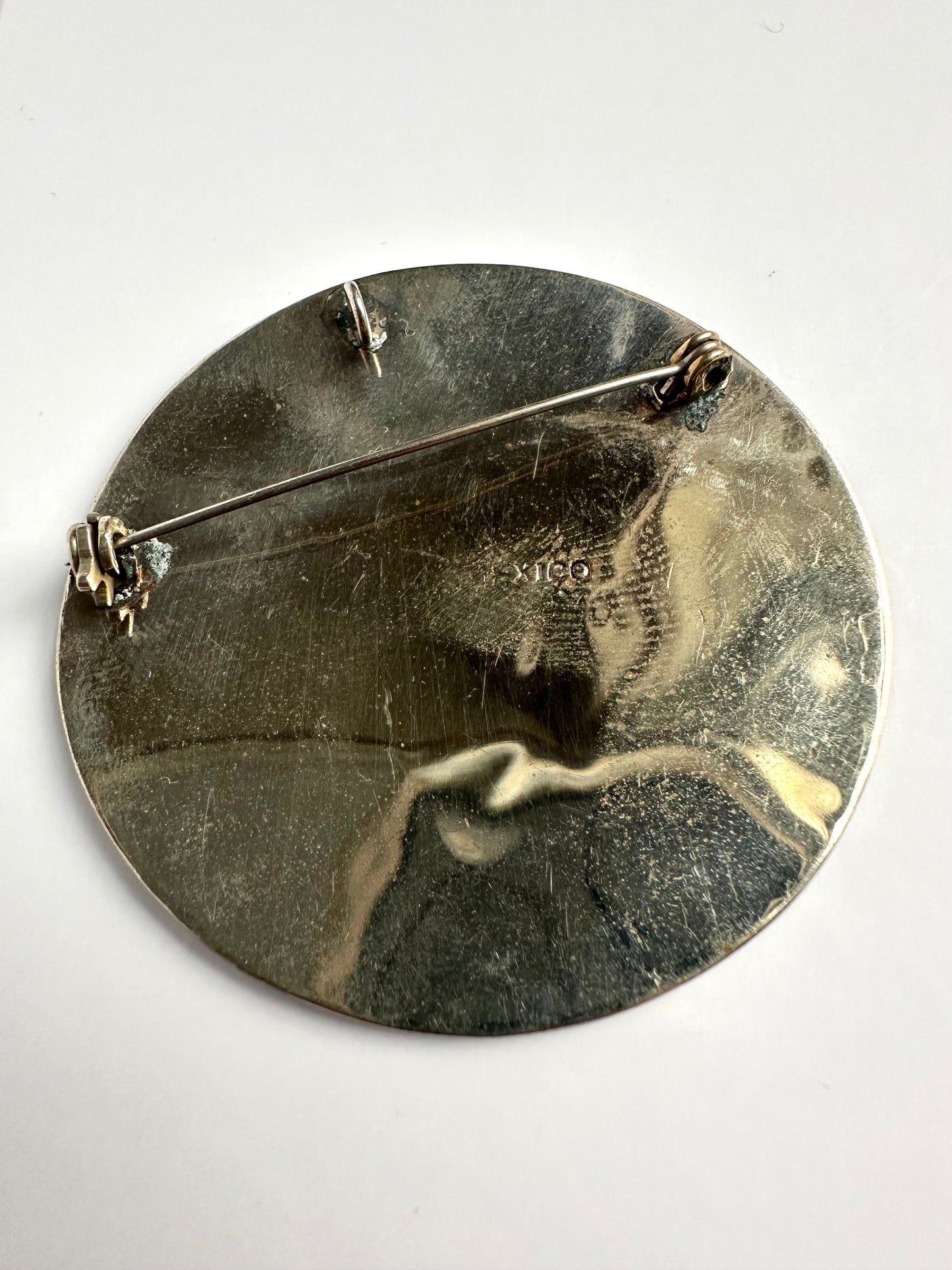 Achterkant van vintage zilverkleurige ronde broche