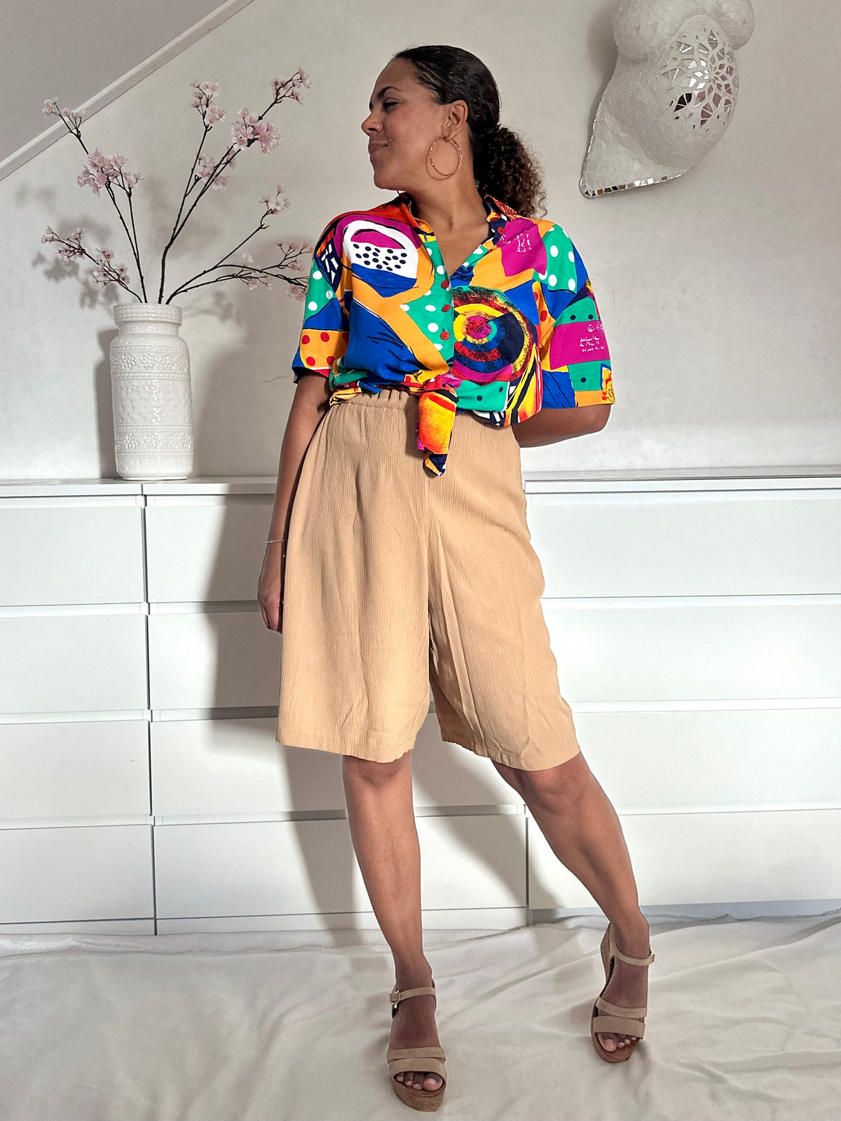 Felgekleurde jaren negentig blouse gedragen op een beige bermuda 