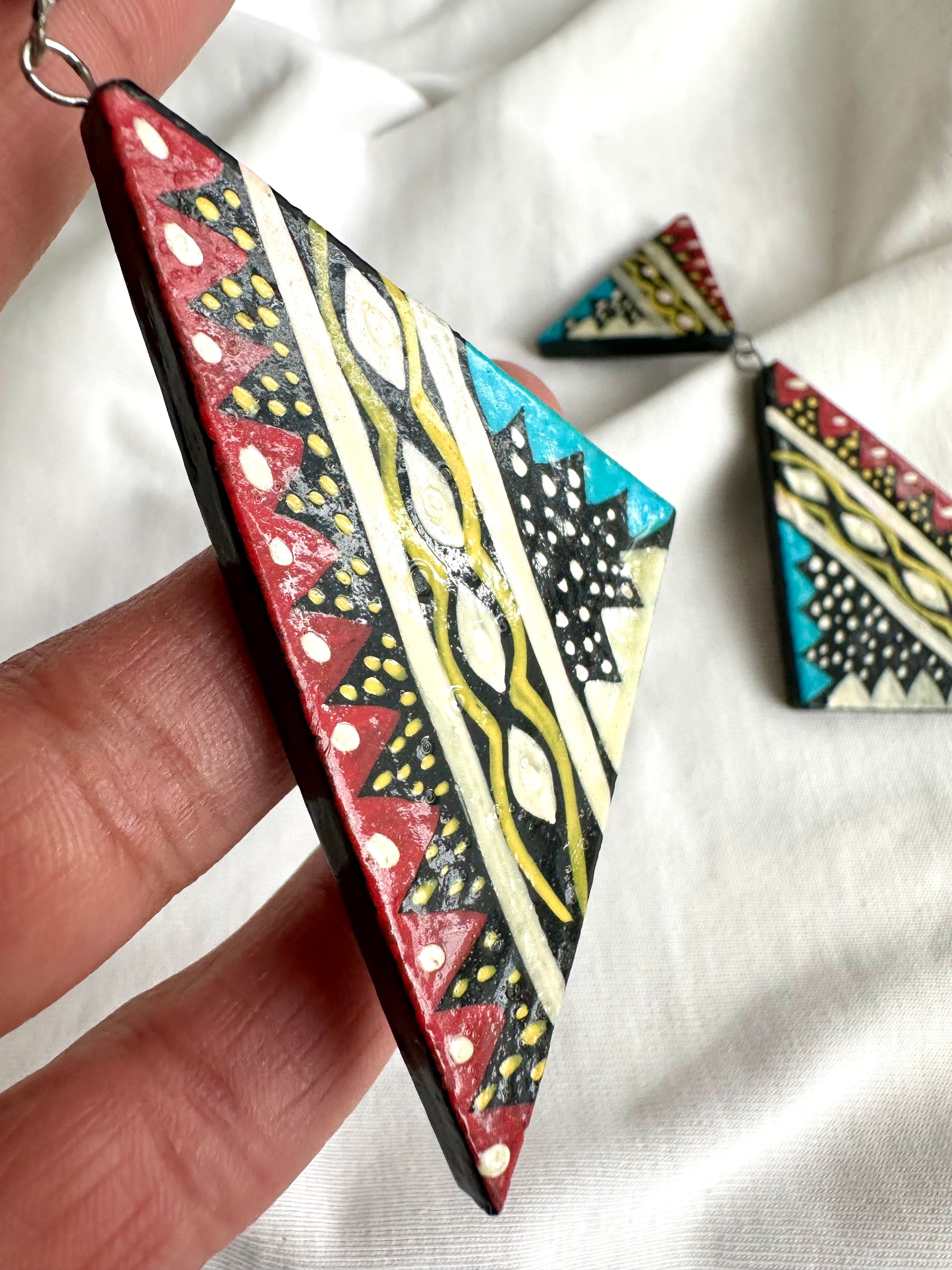 Detailfoto van retro oorhangers met inheemse print, met de hand beschilderd