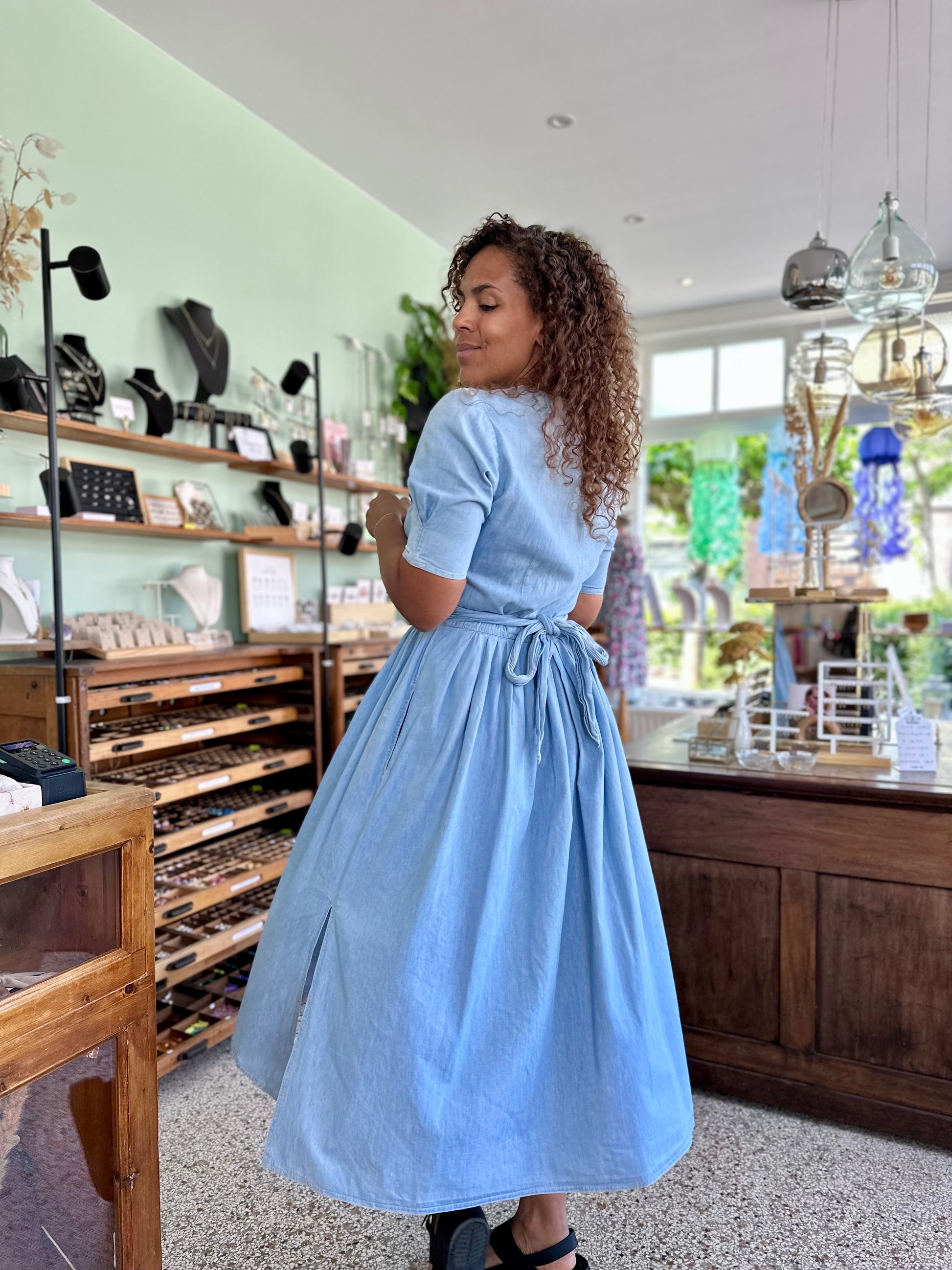Vrouw draagt kleurrijke tijdloze vintage jurk, zelfverzekerd en stijlvol – duurzame vintage kleding bij The Comeback Store