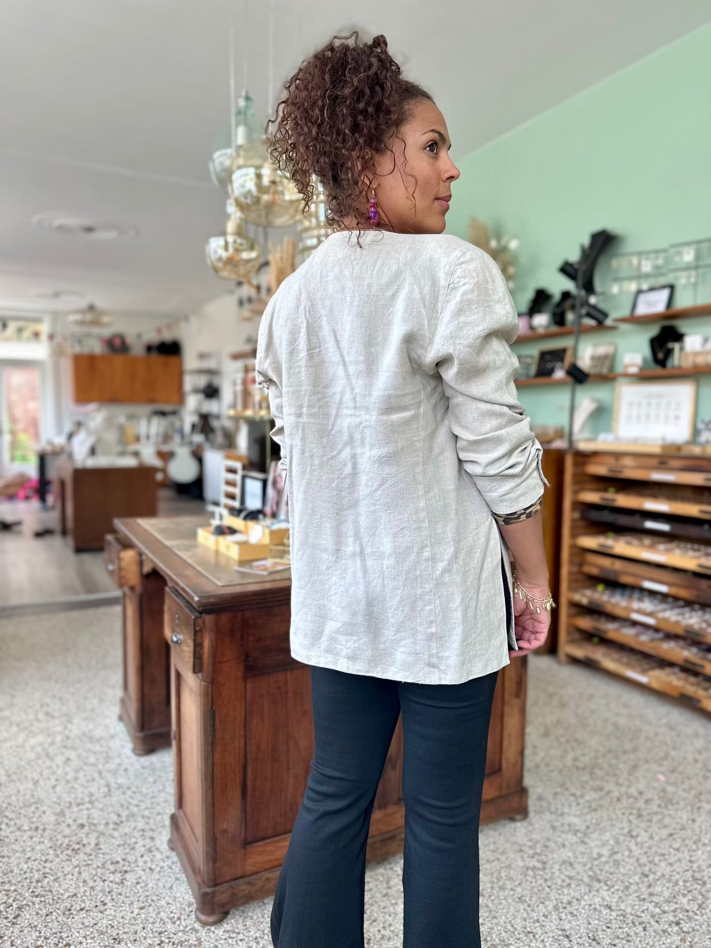 Achterkant van vintage stijl jasje met grote schouders en opgestroopte mouwen voor casual effect