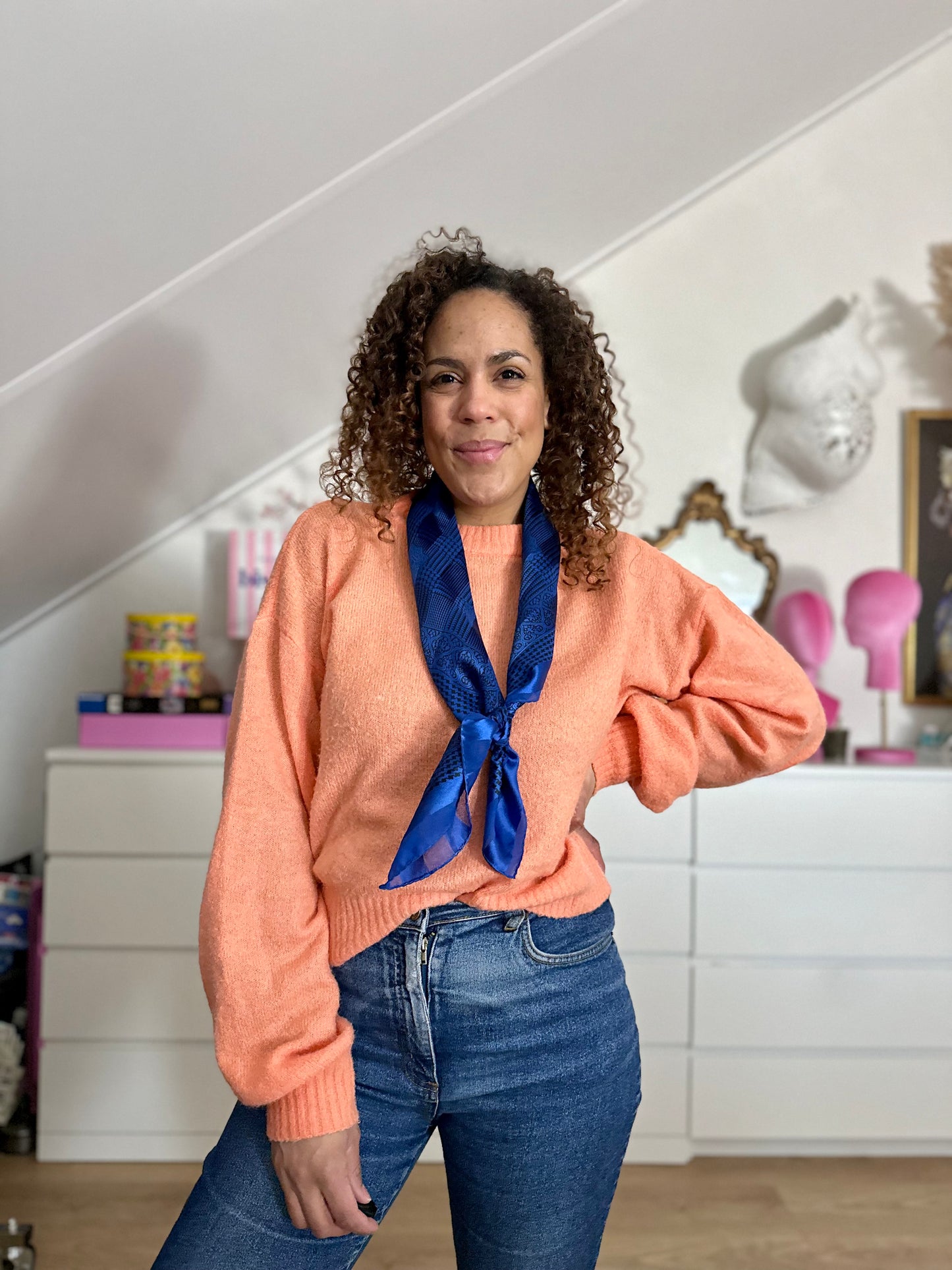 Het sjaaltje gedragen om de nek met een lage knoop voor meer variatie 