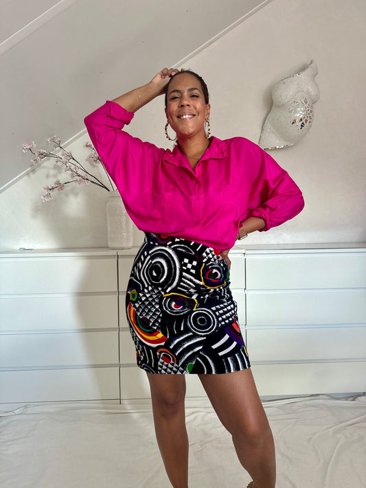 Vintage zwarte minirok met grafische cirkelprint, gecombineerd met roze blouse