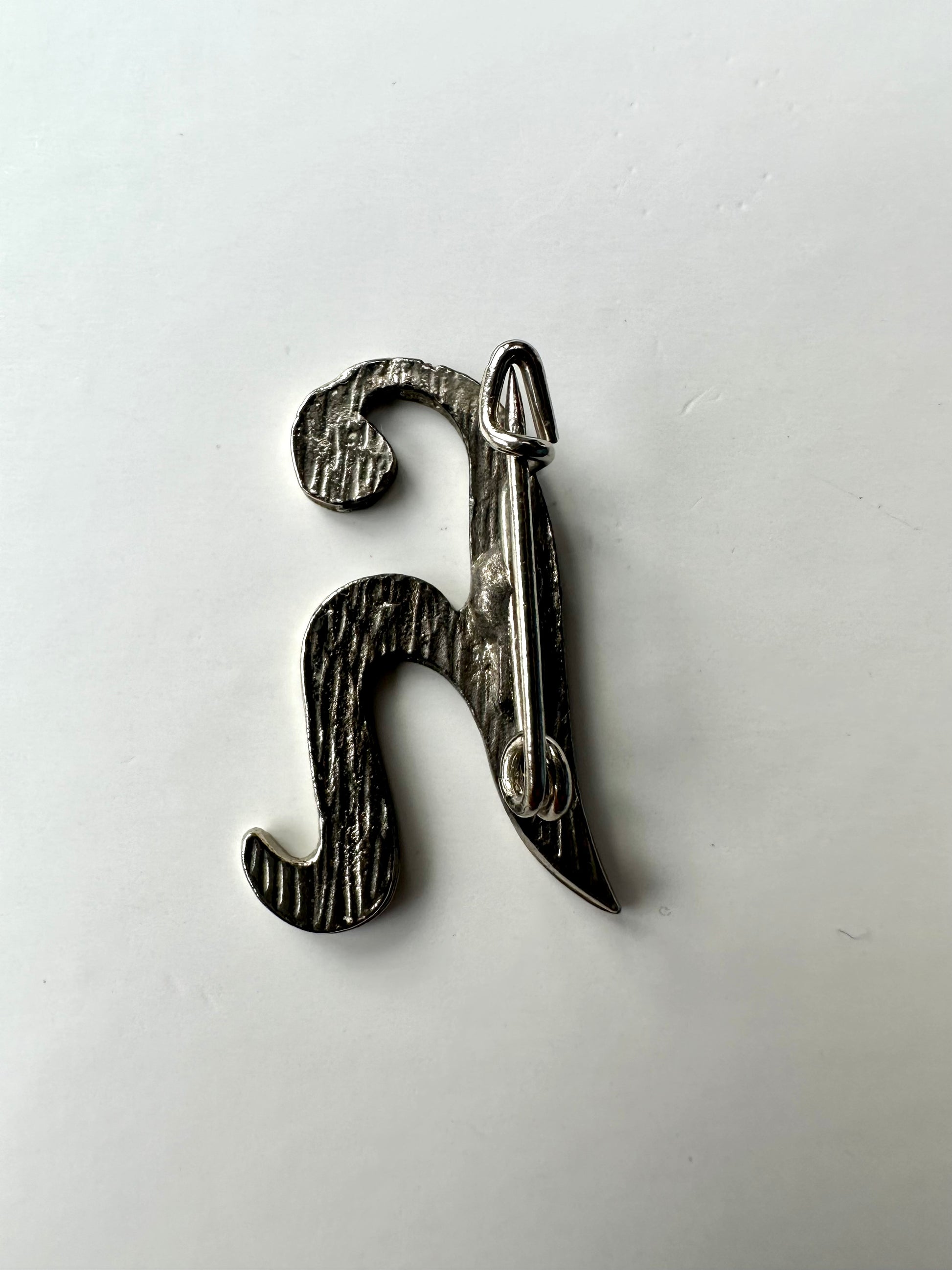 Achterkant van sierlijke letter H broche 