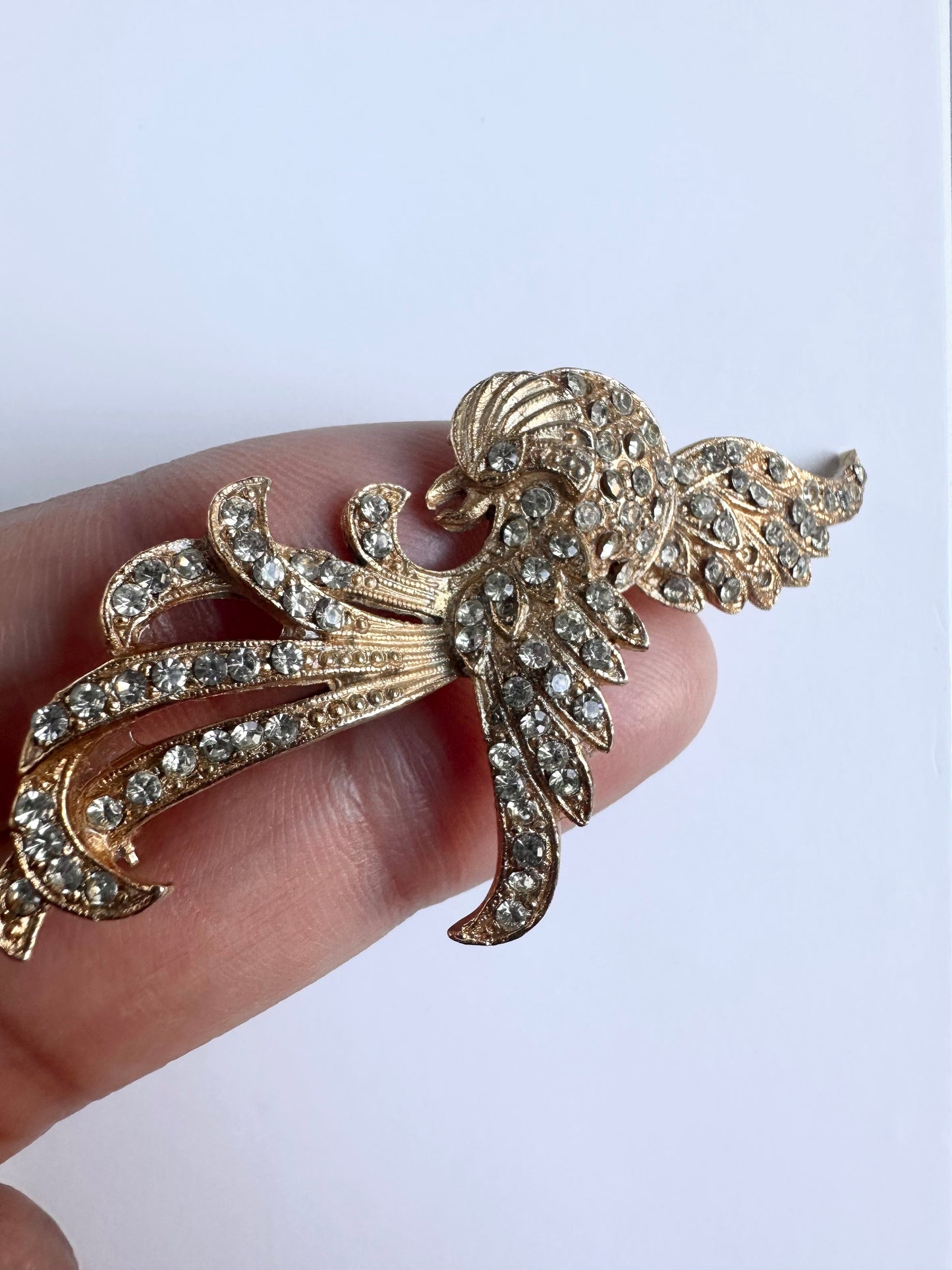 Goudkleurige retro broche in Phoenix vorm, bewerk met talloze zilveren strass steentjes 