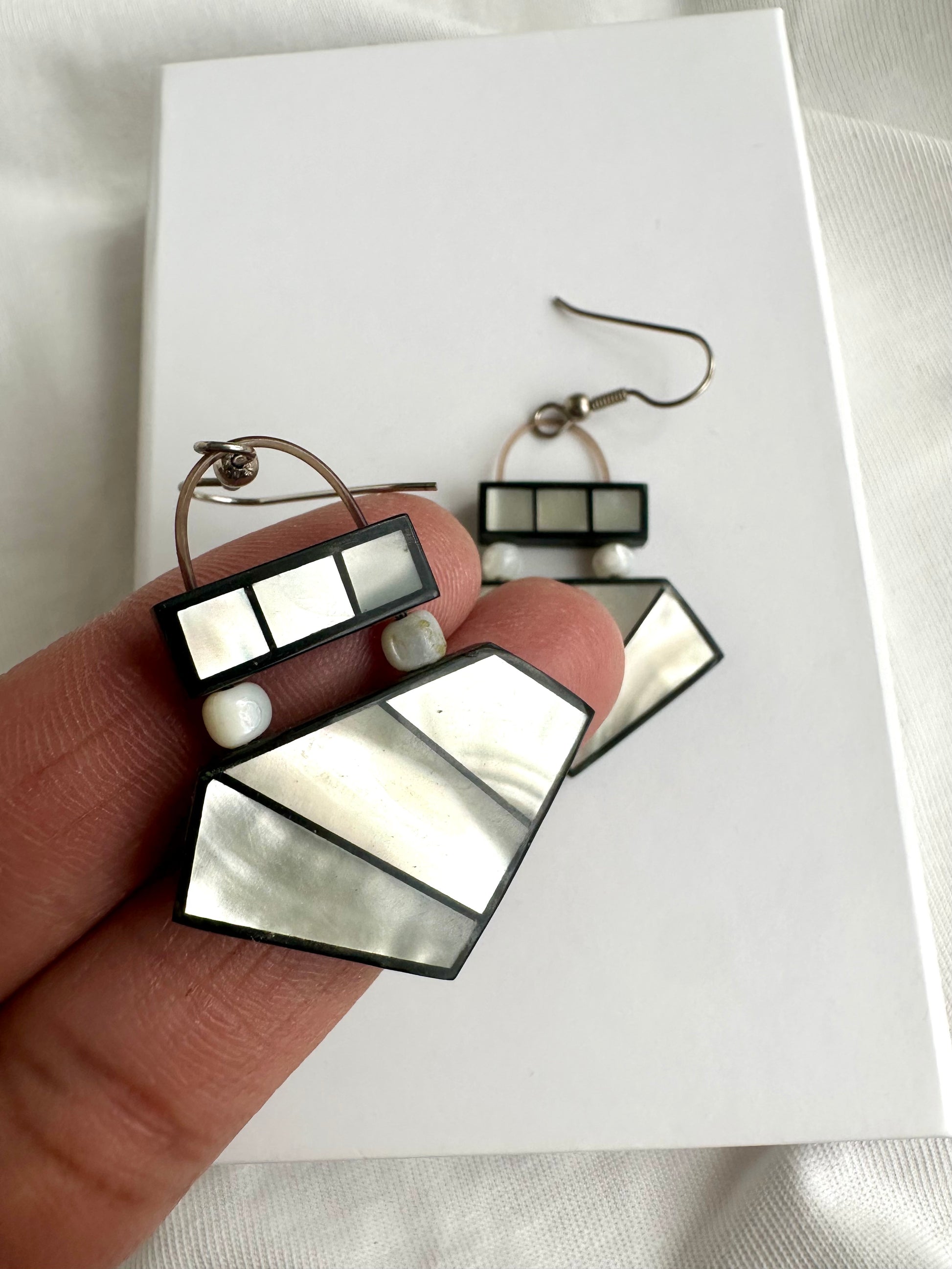 Detailfoto van vintage oorbellen met glanzend parelmoer effect