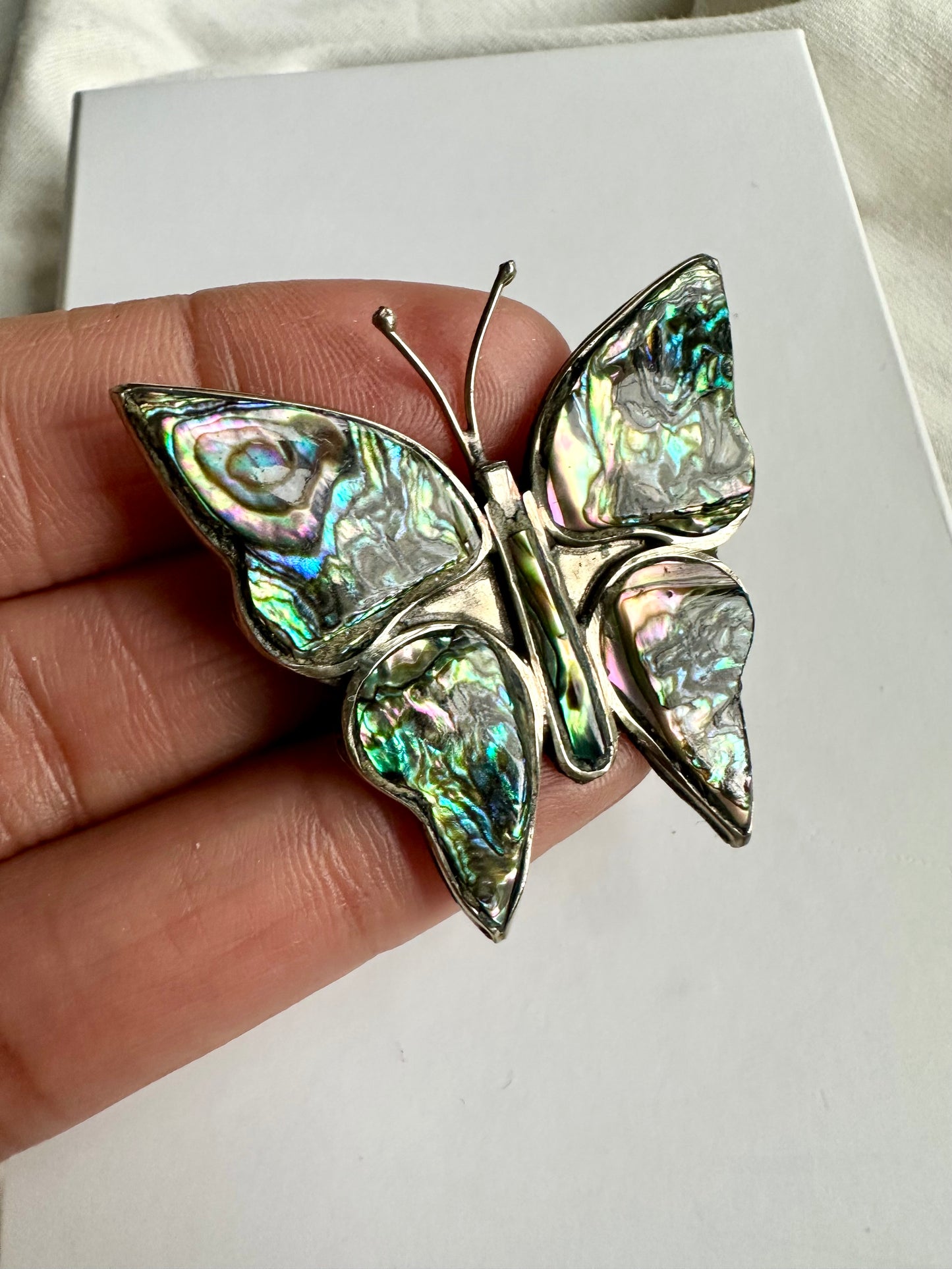 Zilverkleurige vintage broche in de vorm van een vlinder, ingelegd met albalone schelp 