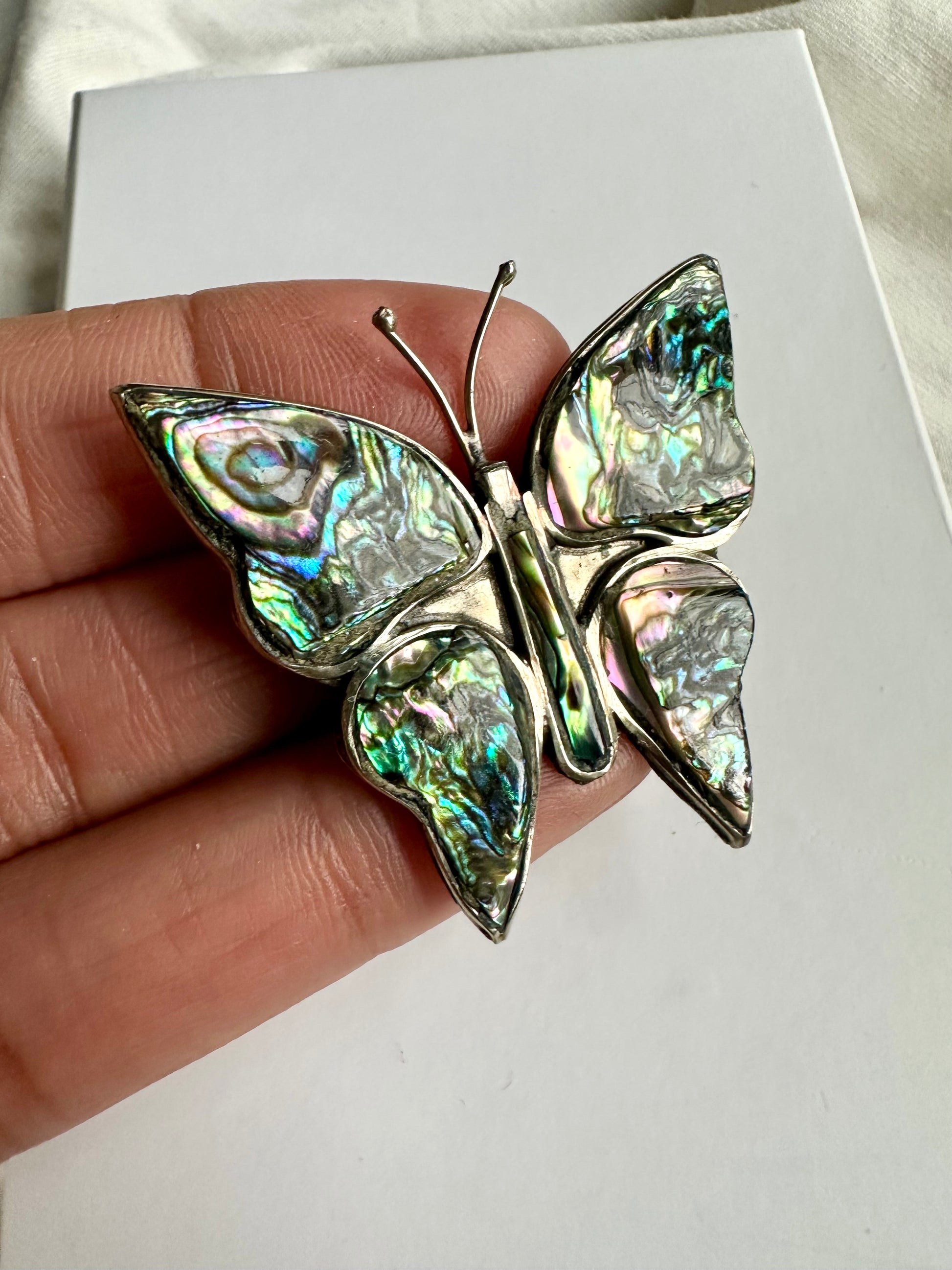 Zilverkleurige vintage broche in de vorm van een vlinder, ingelegd met albalone schelp 