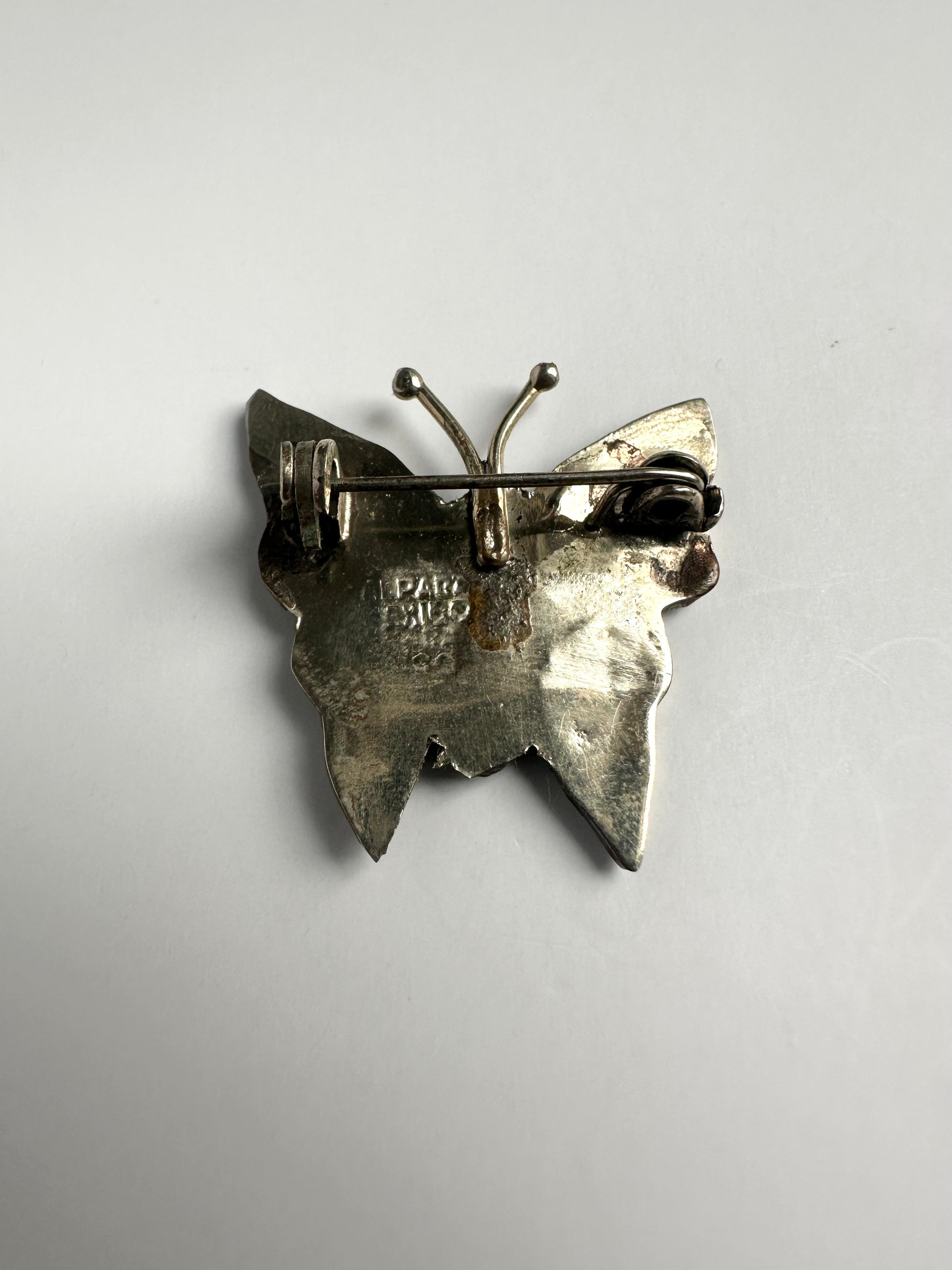 Achterkant van vlinder broche met de graveringen in beeld
