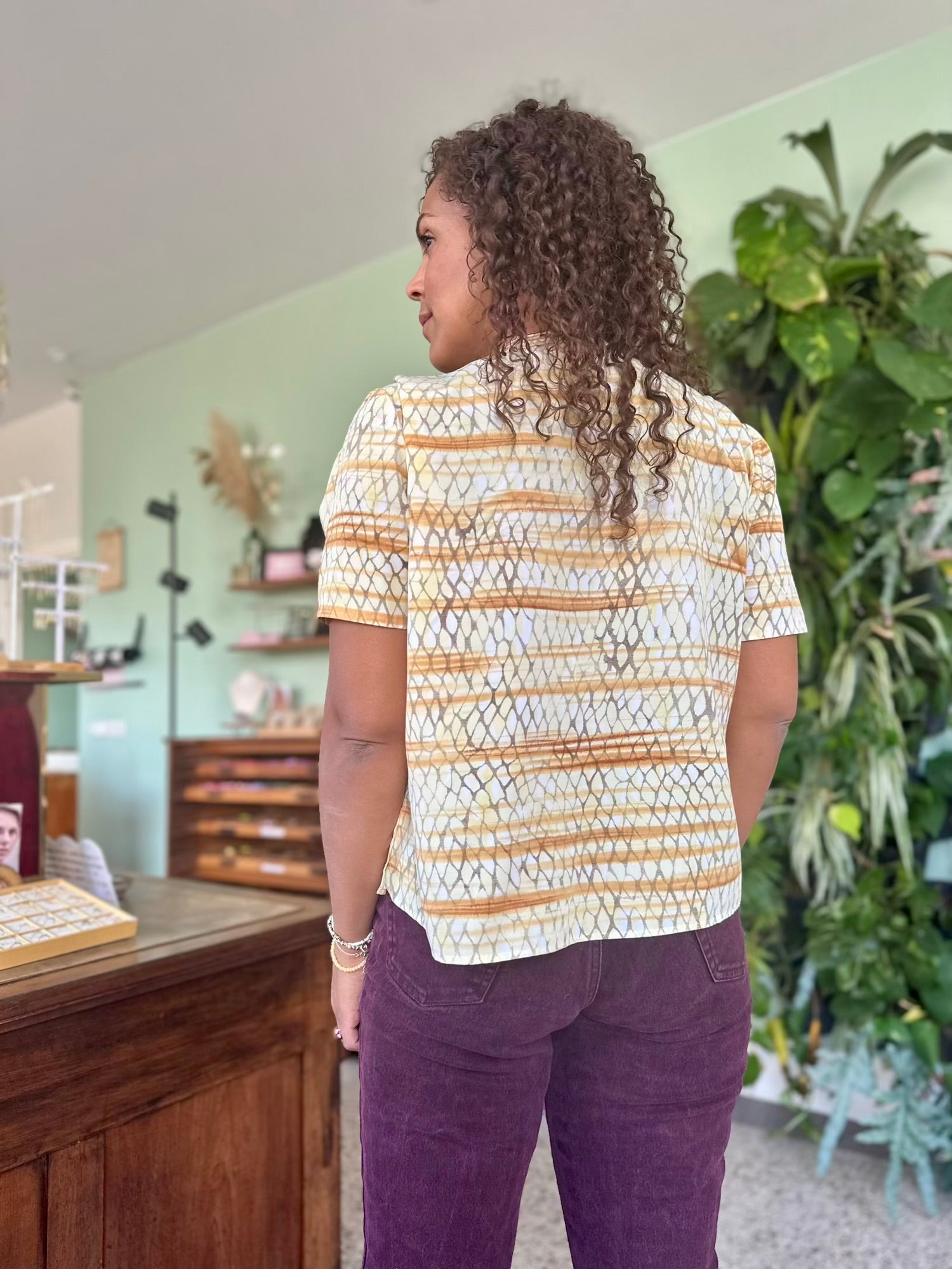 achterkant van retro blouse met slangen patroon in wit bruin en goud tinten