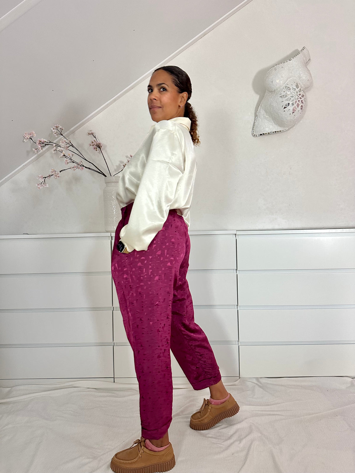 Zij-aanzicht van vintage stijl broek met lichte glans in aubergine kleur 