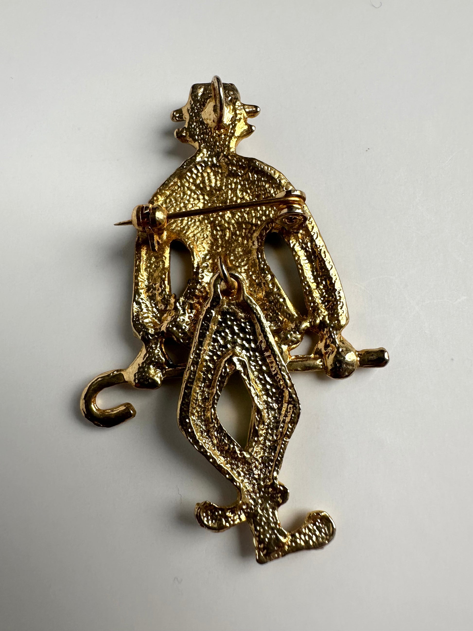 Achterkant van goudkleurige retro broche in vorm van clown