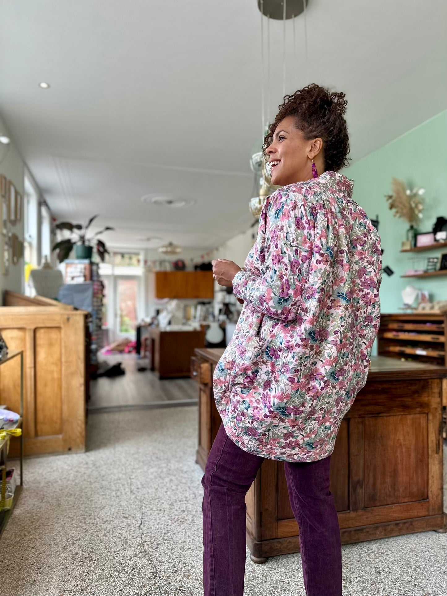 achterkant van vintage jas uit de jaren tachtig met grote schouders en plooien, een volledige floral print in diverse roze tinten