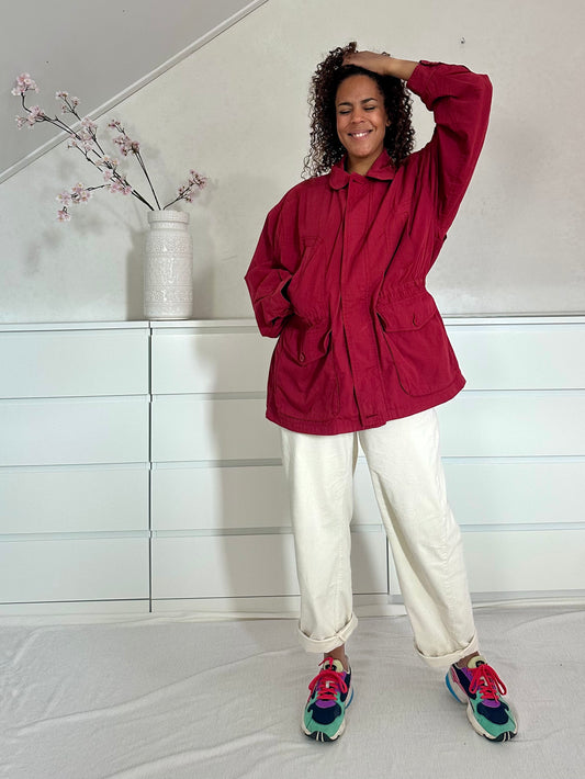 Vintage framboosrode jas met tunnelkoord in de taille en oversized pasvorm.