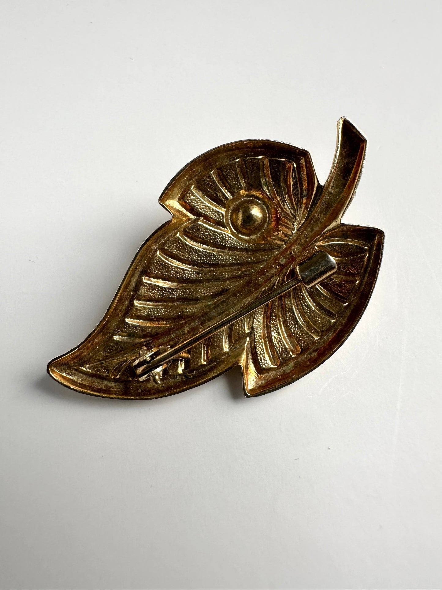 Achterkant van retro gouden broche in vorm van een blaadje