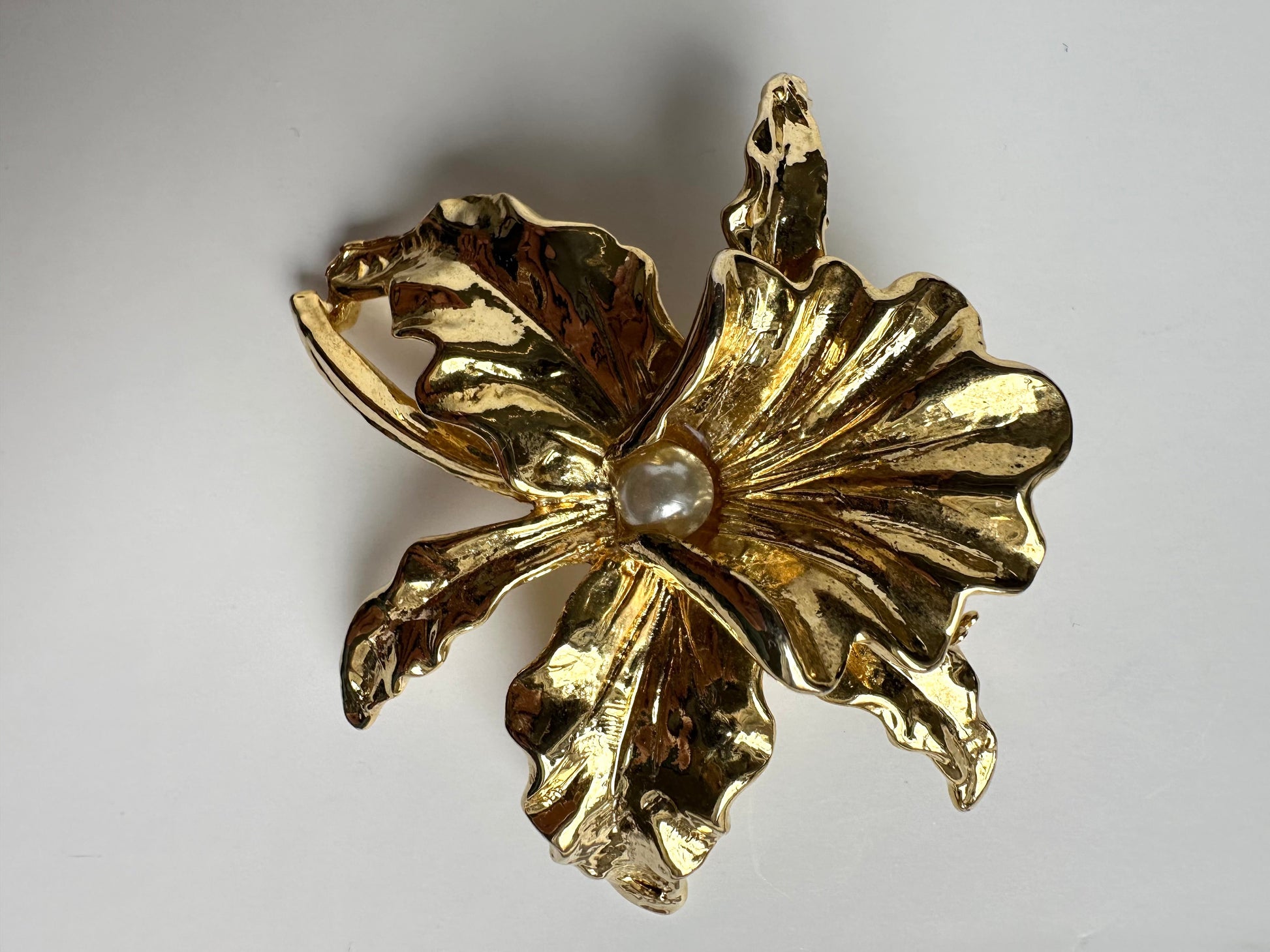 Vintage goudkleurige broche in de vorm van een bloeiende lelie met faux parel stamper