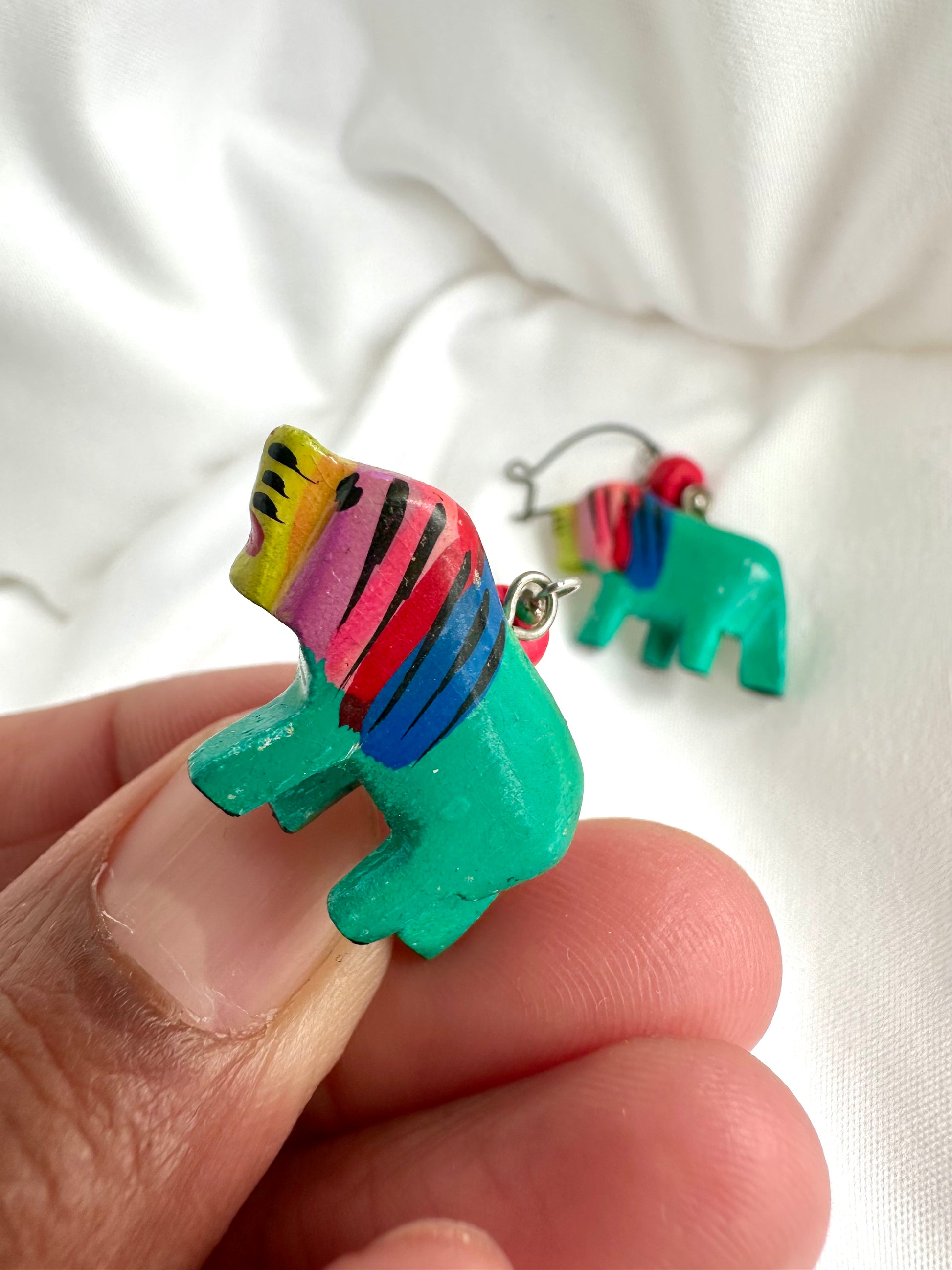 Detailfoto van jaren negentig houten oorbellen in leeuw vorm 
