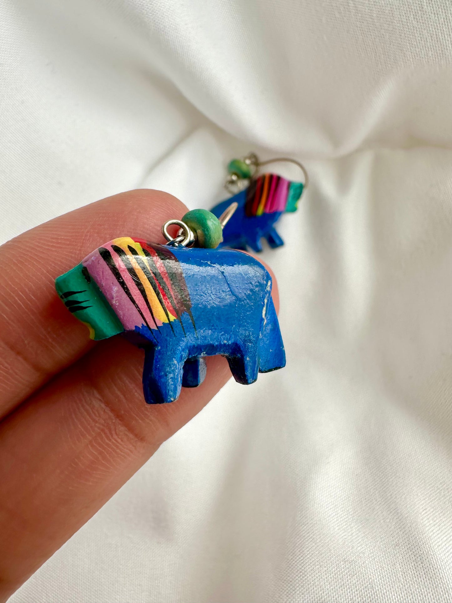 Detail van houten jaren negentig leeuw oorbellen met kleine beschadiging 