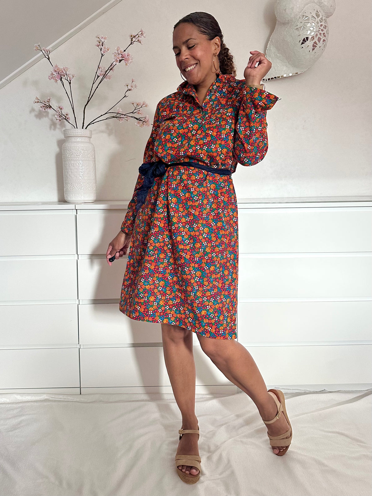 Vintage jurk op knielengte met oranje roze blauwe bloemen en een lint in de taille