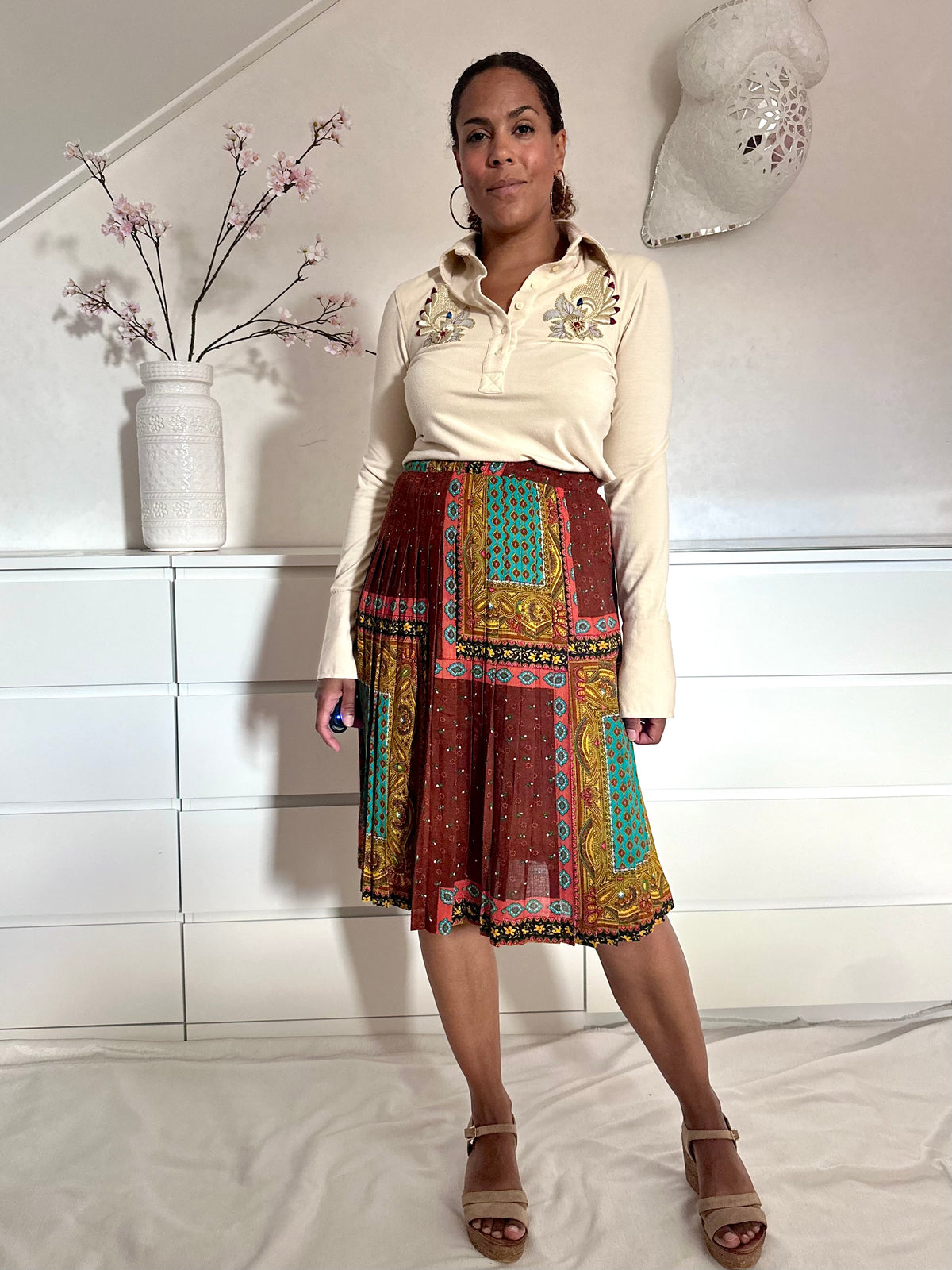 Retro plooirok uit jaren negentig gedragen met beige longsleeve 