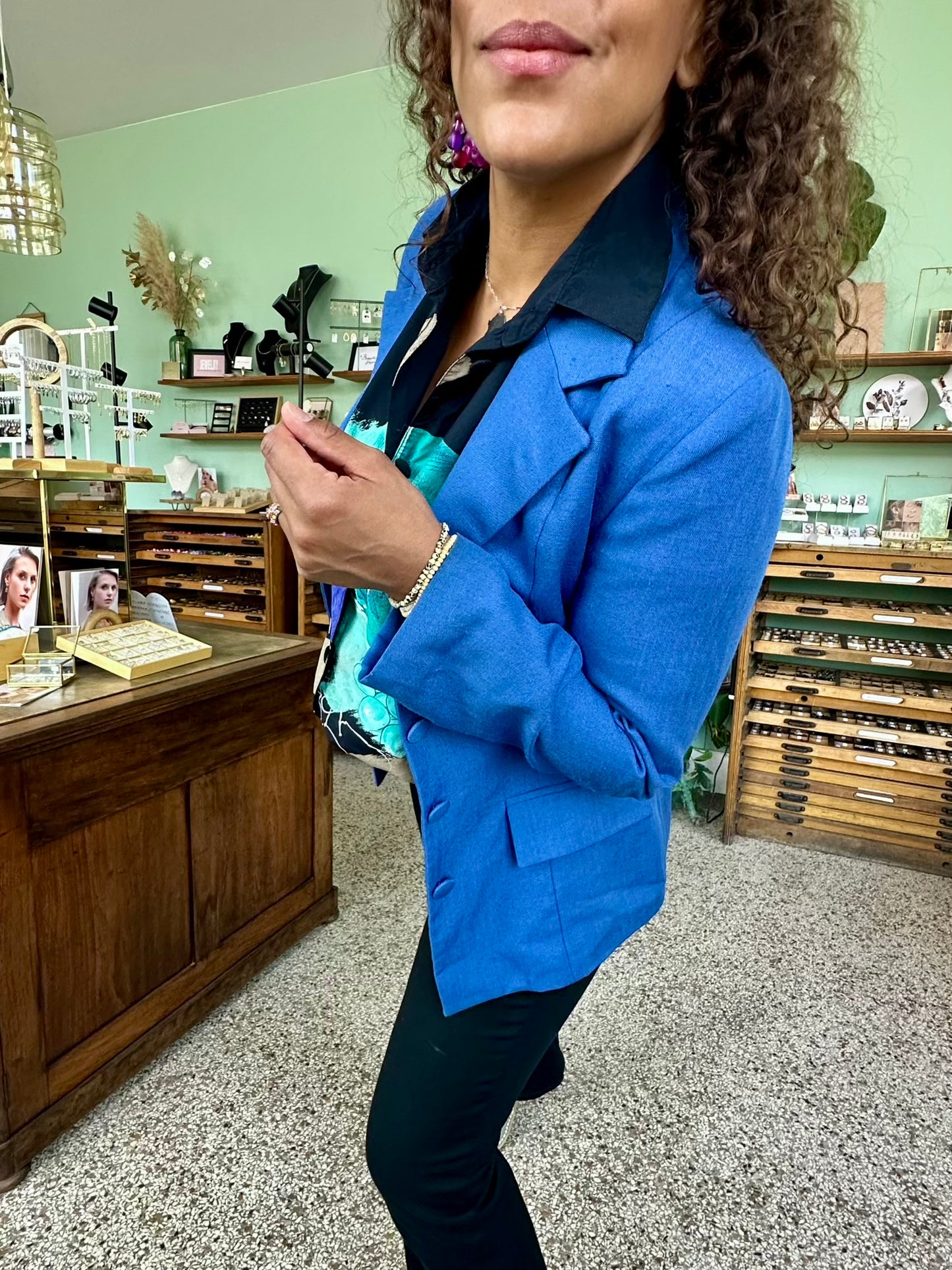 Detailshot van vrouwelijke retro blazer in helder blauw met aangesloten pasvorm