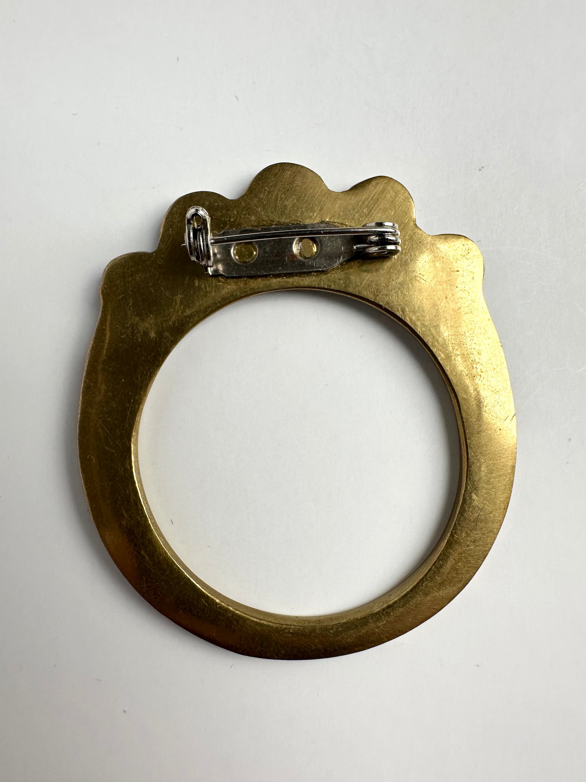Achterkant van vintage koperen ronde broche met parelmoerschelp