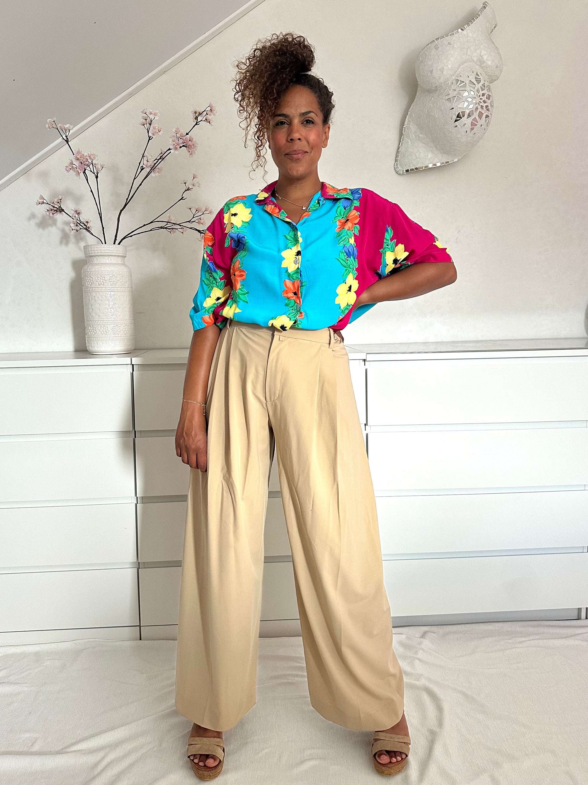 Retro top in turquoise en roze, blousend in de broek gedragen