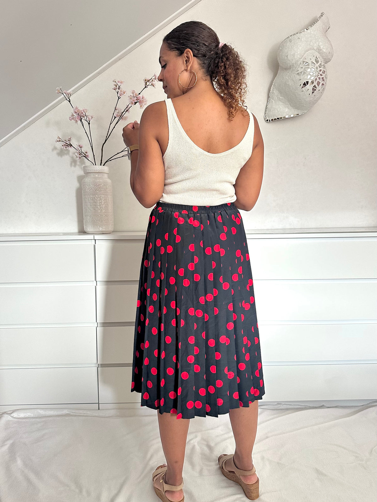 Achteraanzicht van vintage polka dot rok in zwart met rood en hoge taille 