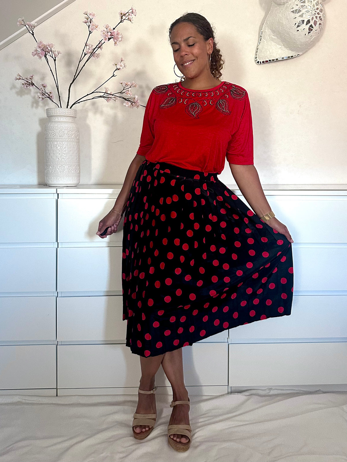 Retro plissé rok in zwart met rode stippen, gedragen met een rood tshirt