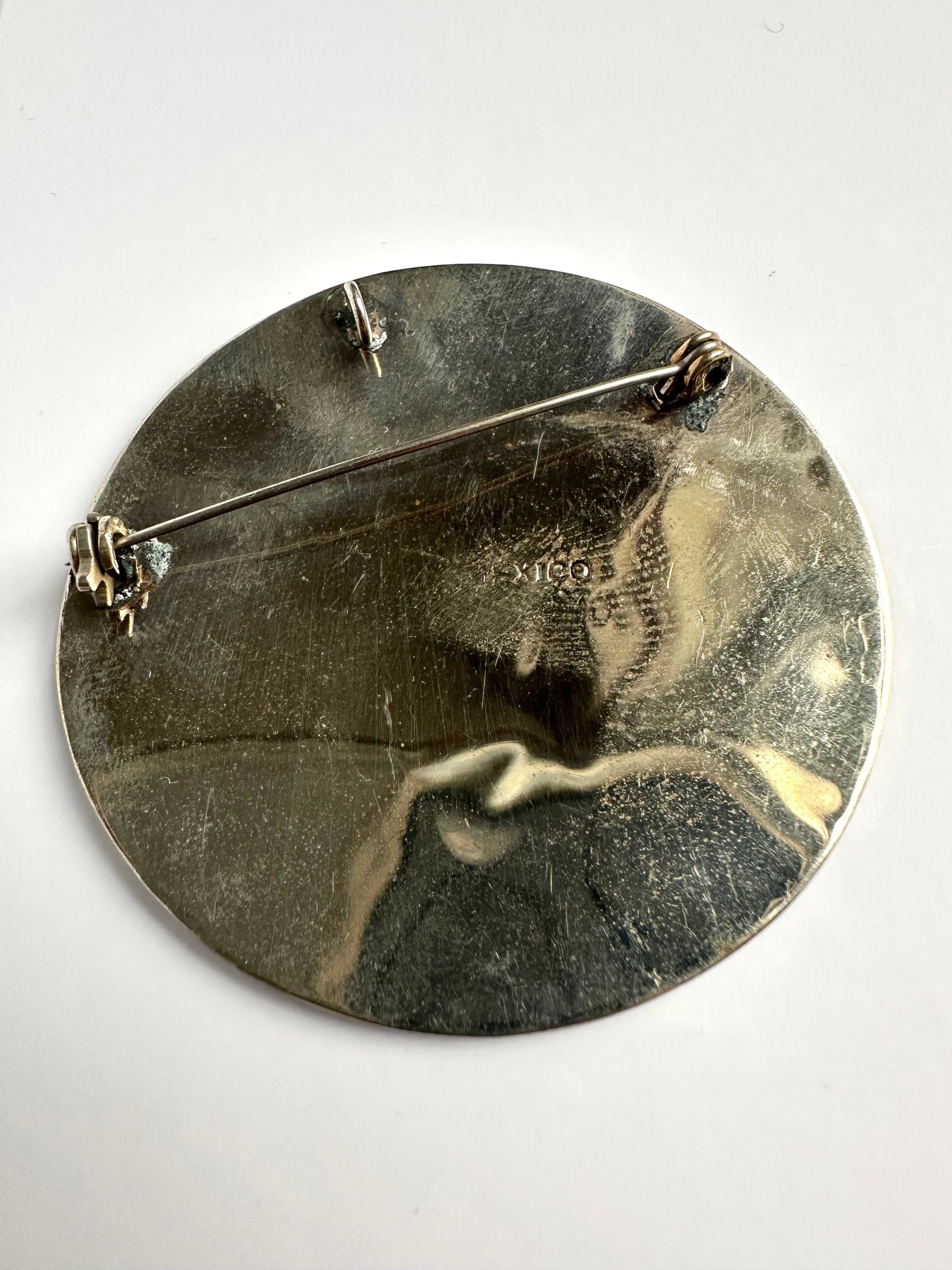 Achterkant van vintage zilverkleurige ronde broche 