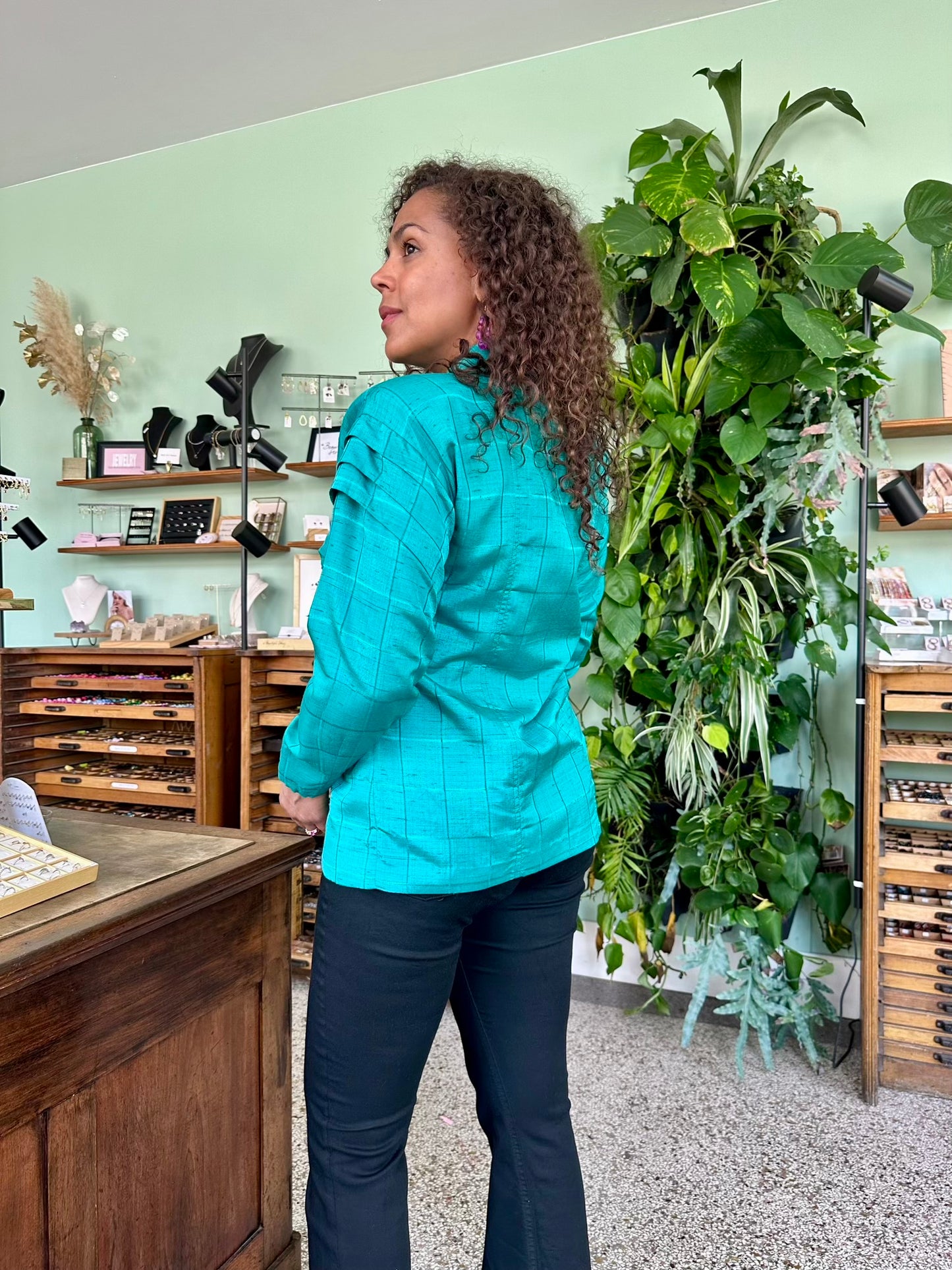 Achterkant vintage stijl blouse met glanzende stof, jaren tachtig snit en elegante plooien bij schouders