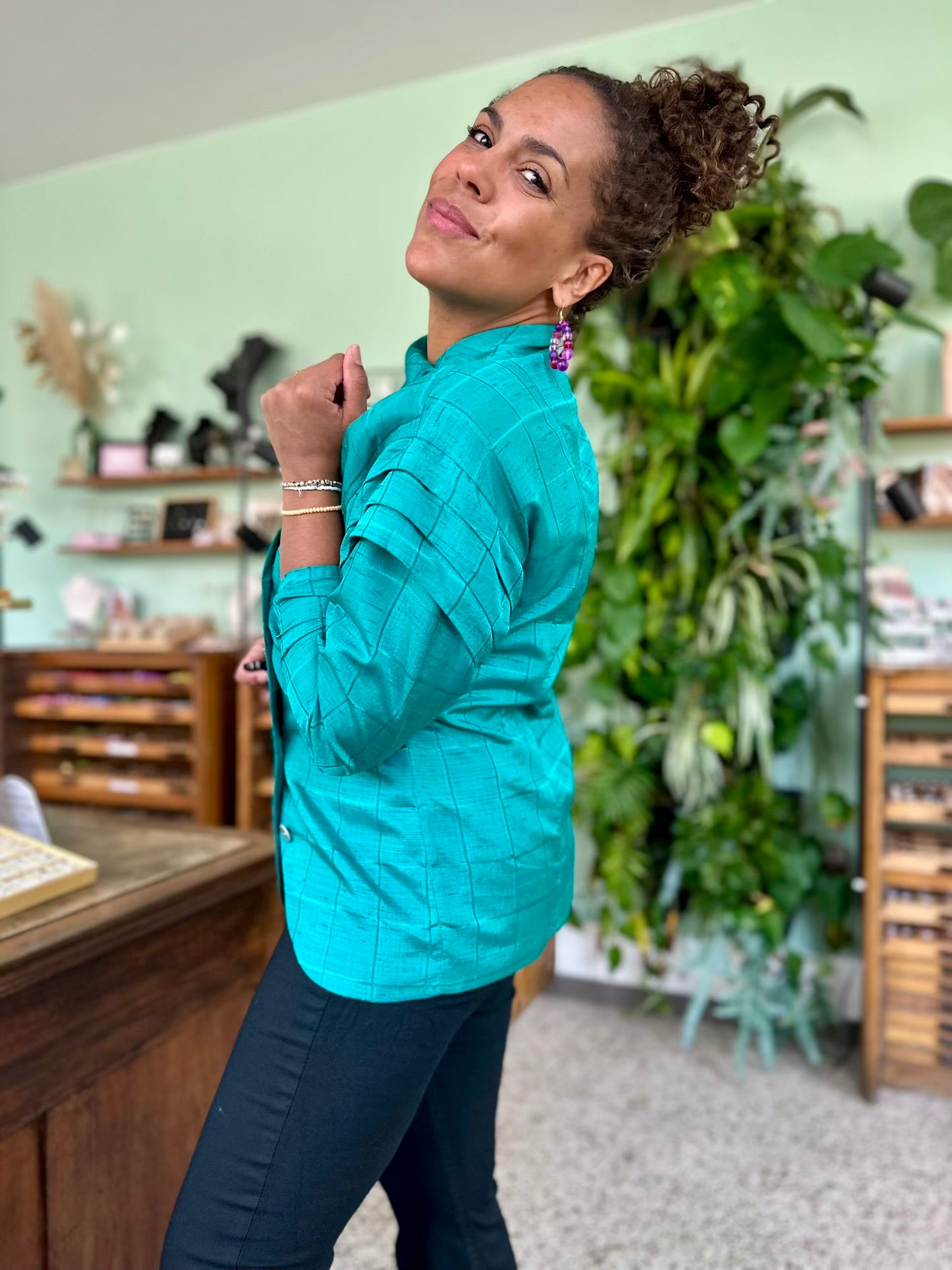 Retro blouse in jaren tachtig stijl met overslag detail op schouders in helder turquoise opvallend en elegant