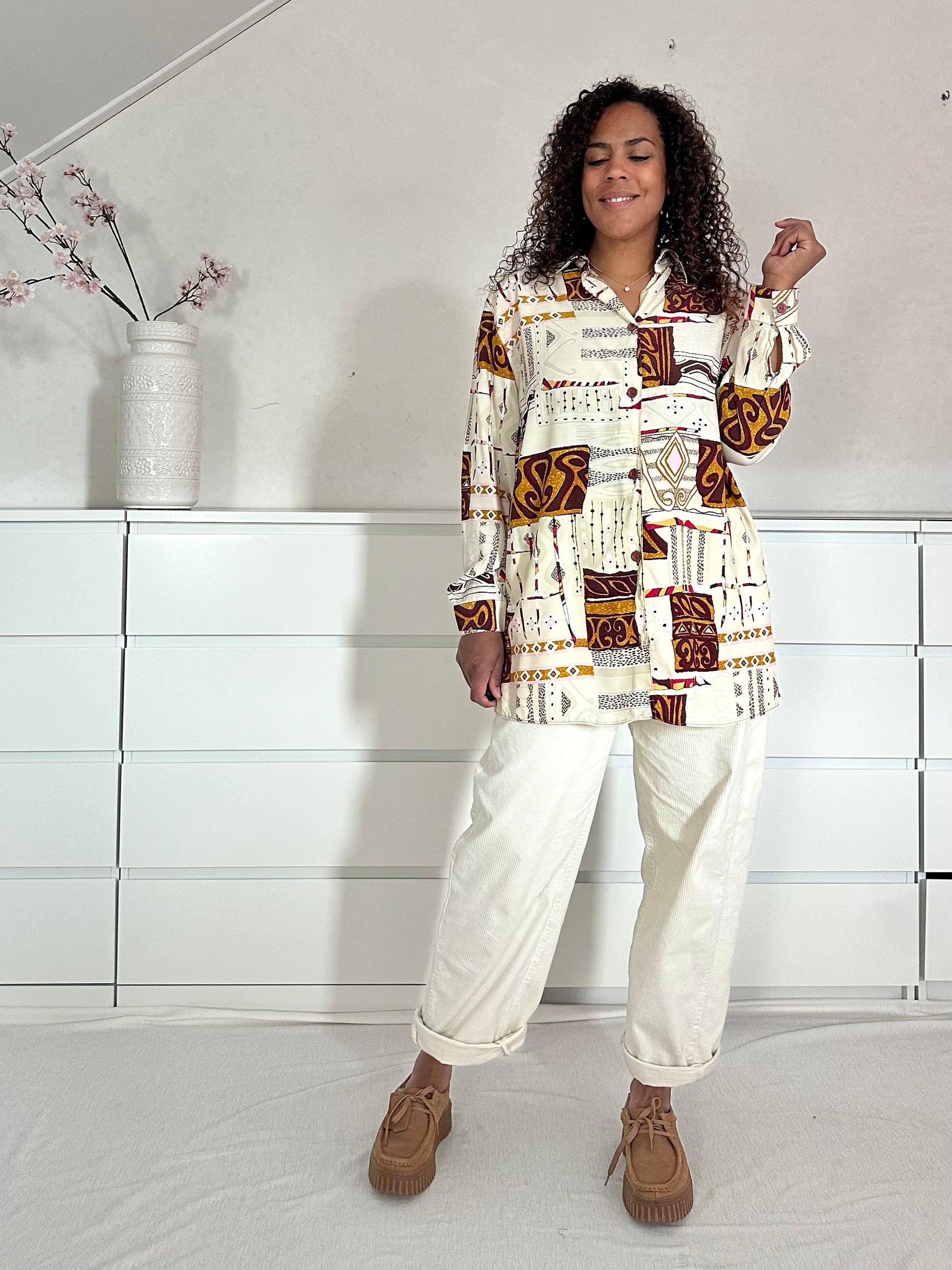 Vintage damesblouse met geometrische print en lange mouwen, vooraanzicht.
