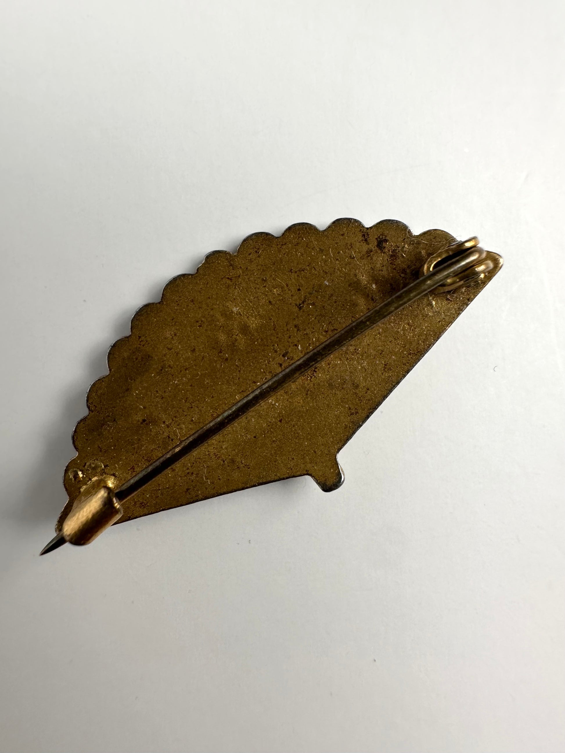 Achterkant van retro bronskleurige broche in waaier vorm