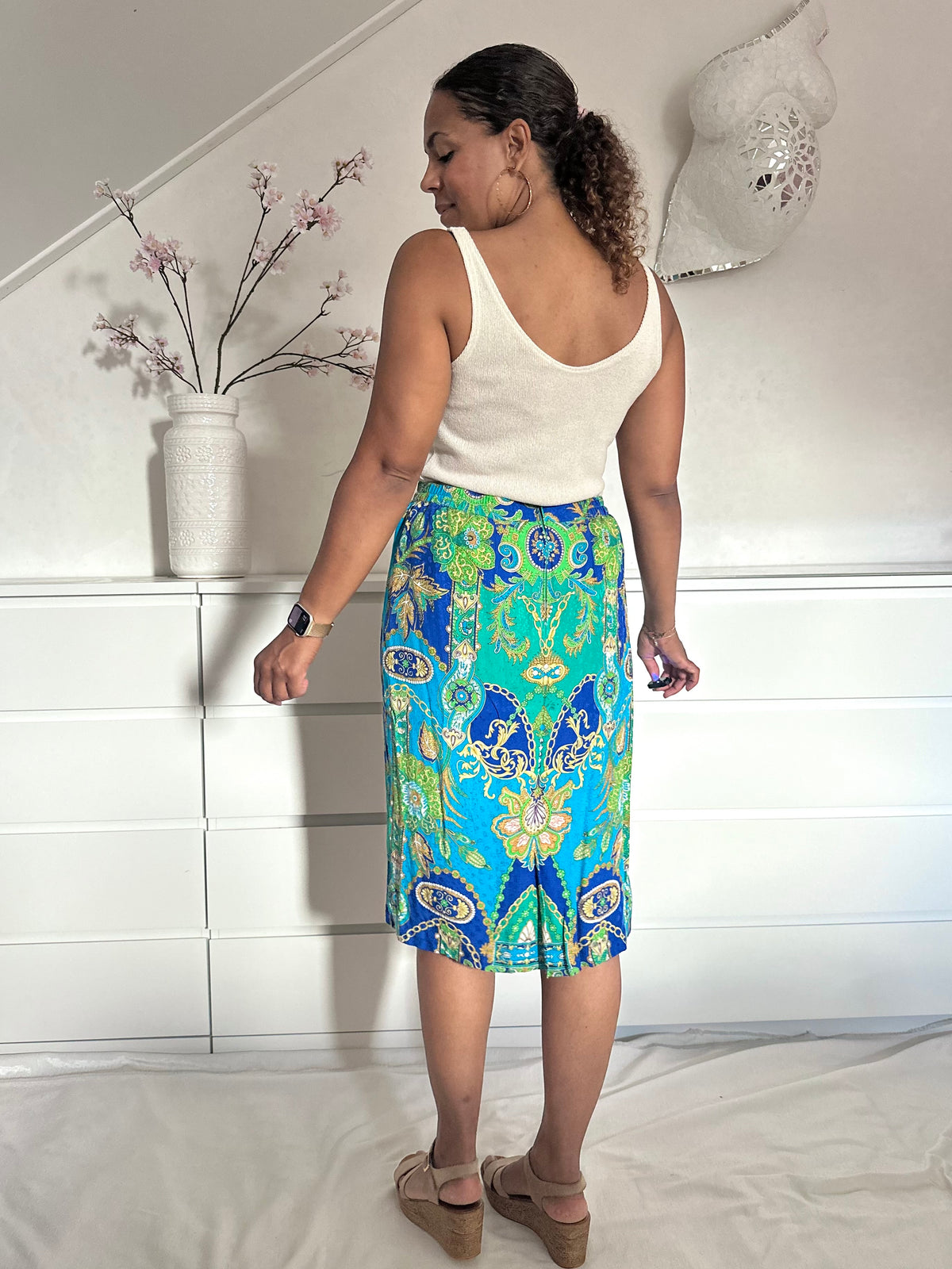 Achterkant van retro kokerrok in colorblock kobalt blauw, turquoise en goud 