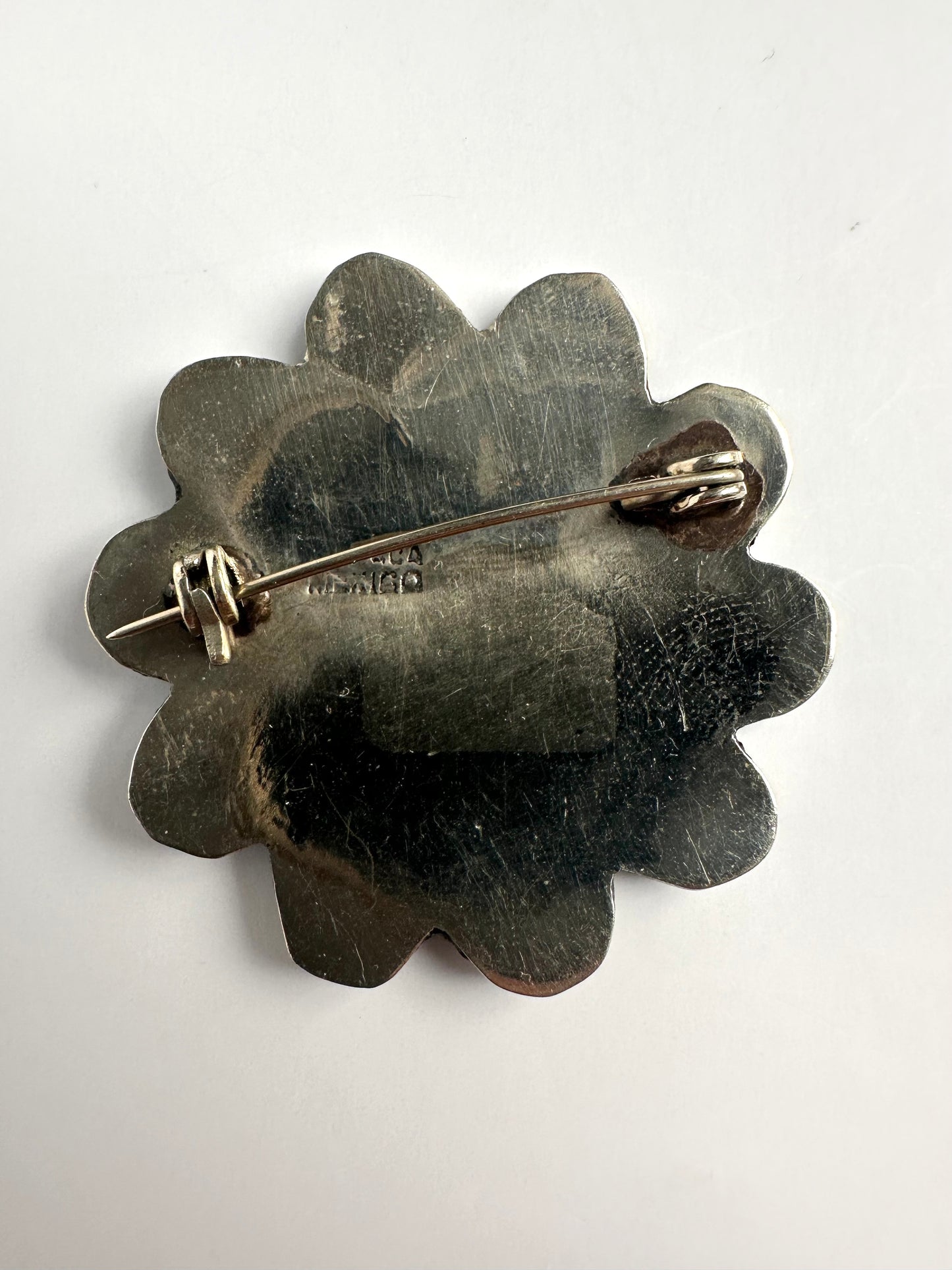 Achterkant zilverkleurige broche met alpaca inscriptie 