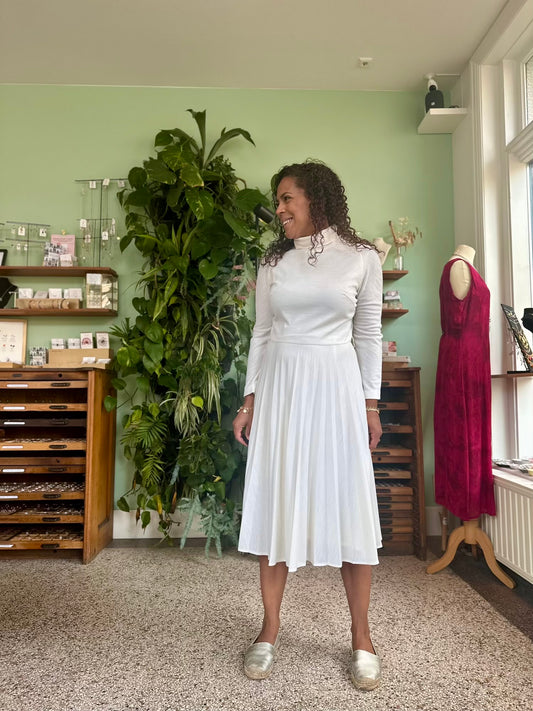 Vintage hagelwitte jurk met hoge sluiting en sierlijke plooien