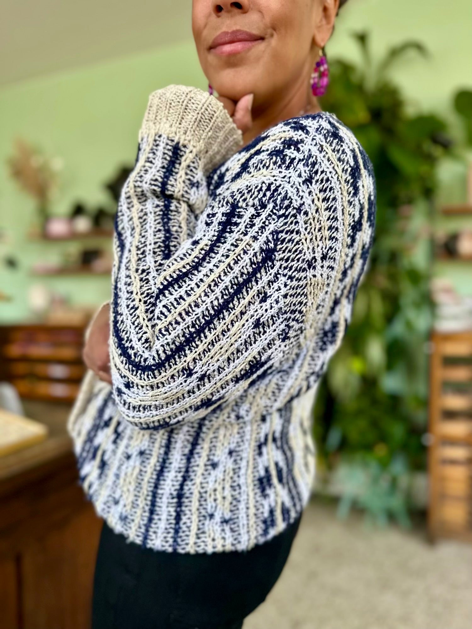 Detailshot van grof. gebreide sweater in gemêleerd patroon van wit creme en donkerblauw, unisex model perfect voor tussenseizoen 