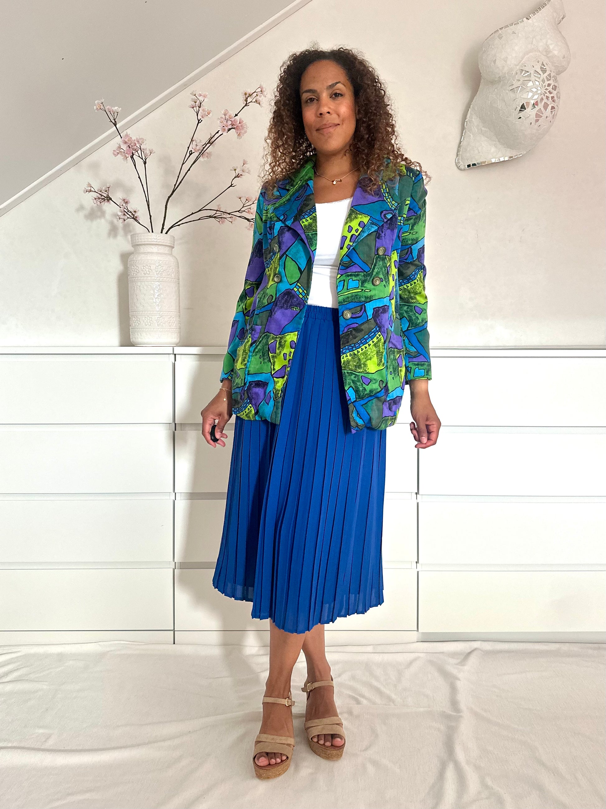 Vintage blauwe midi-rok gedragen met een felgekleurde blazer