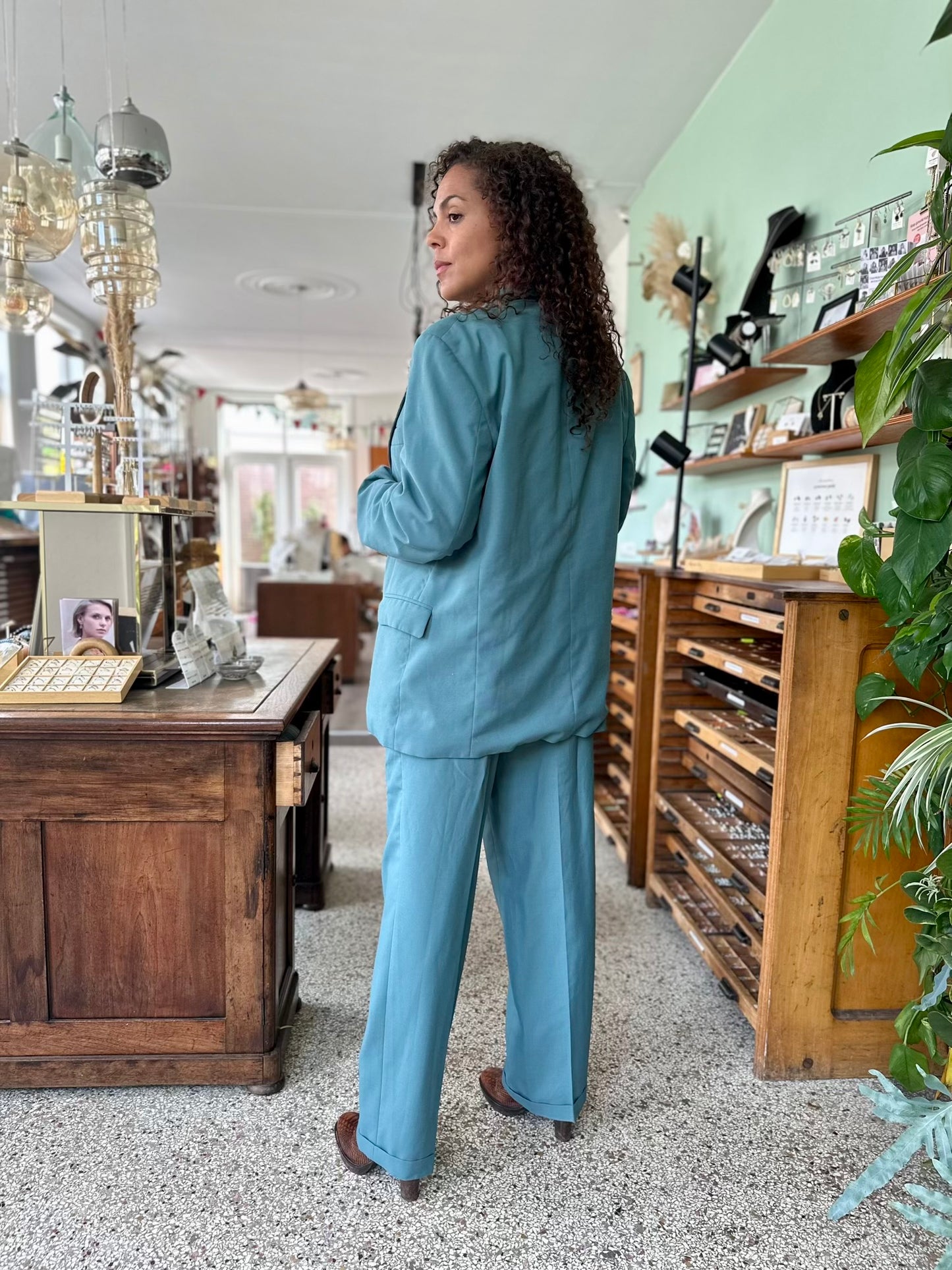 achterkant van retro pak in zeegroen zeeblauwe kleur, voorzien van een colbert en pantalon in grote damesmaat