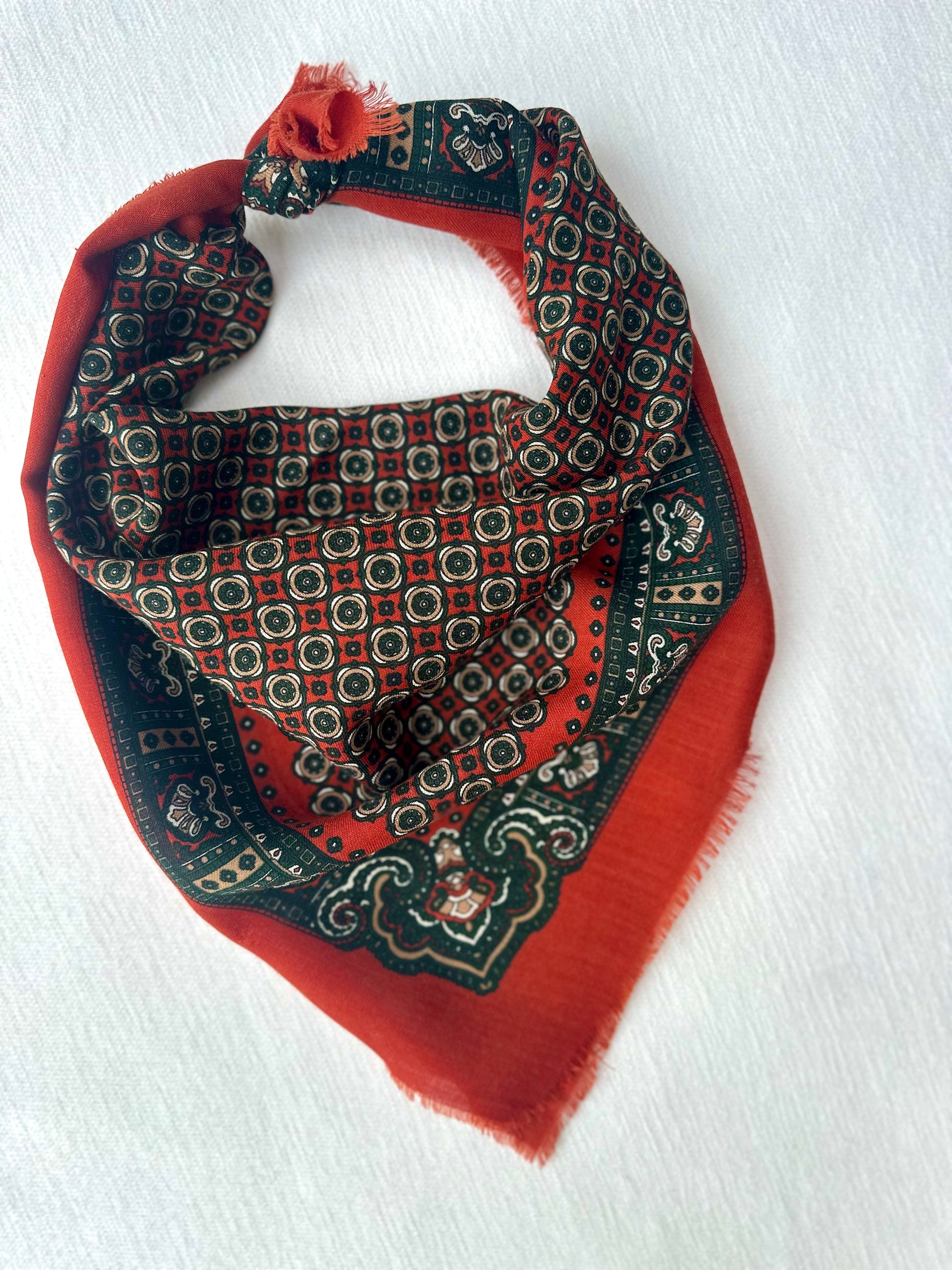 Vintage sjaaltje met print, liggend op een witte achtergrond